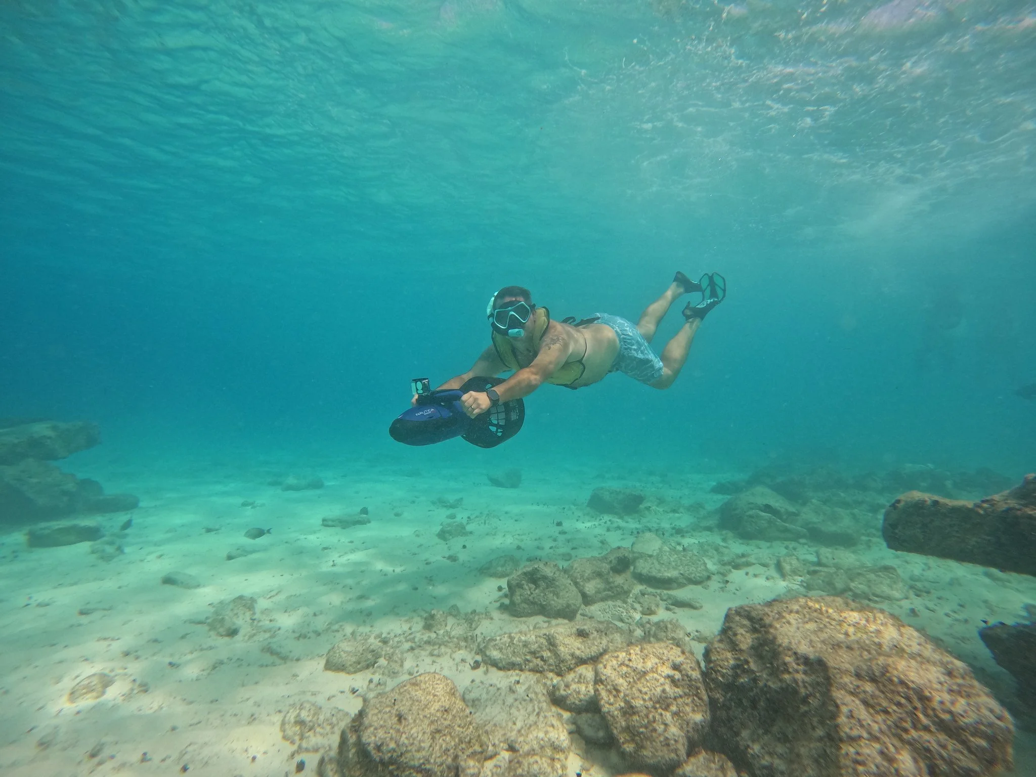 Guest using an underwater scooter during a power snorkeling excursion at Islands Beach Club in Cozumel.