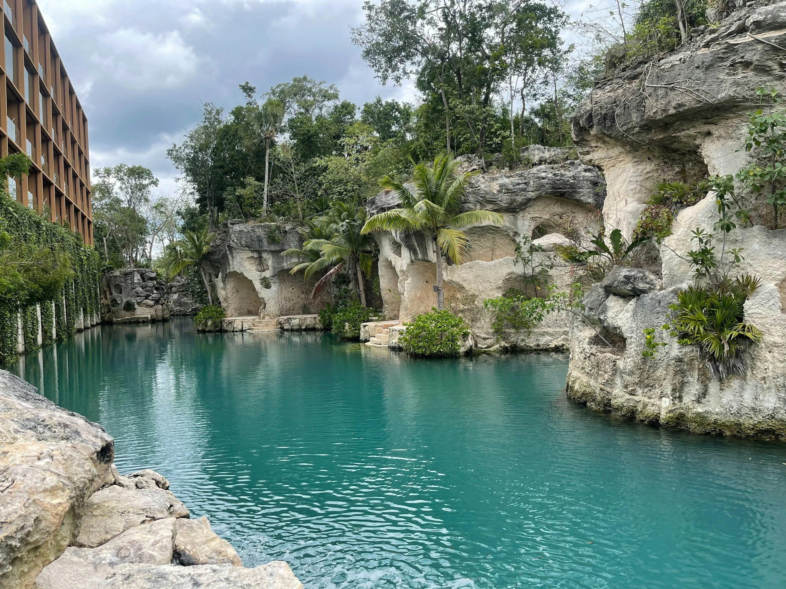 Turquoise river lagoon with natural limestone caves and jungle landscaping at Hotel Xcaret Mexico in Riviera Maya