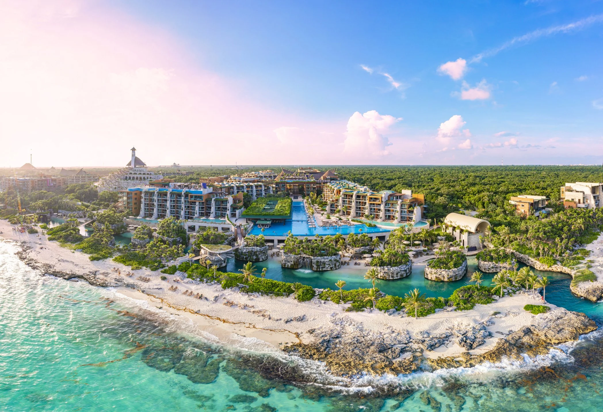 Aerial view of Hotel Xcaret Mexico showing coastline, lagoons, pools, and jungle landscape in Riviera Maya Mexico