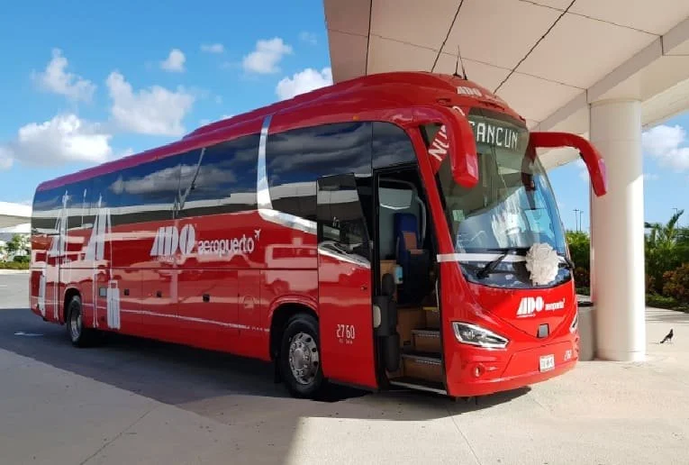 ADO bus driving through Mexico's Riviera Maya, offering affordable and convenient public transportation for tourists and locals