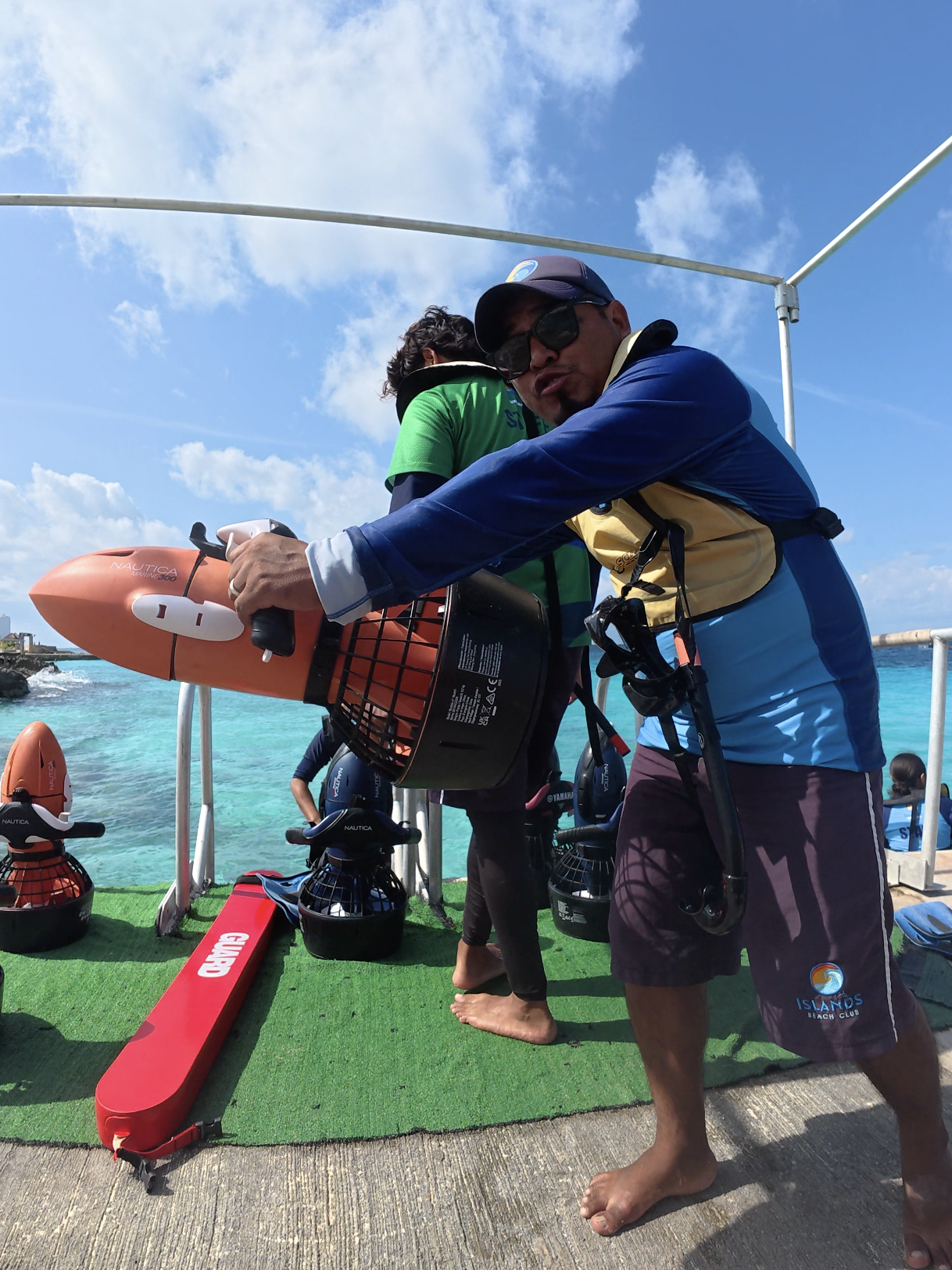 Staff member demonstrating power snorkel equipment before an underwater excursion at Islands Beach Club in Cozumel.