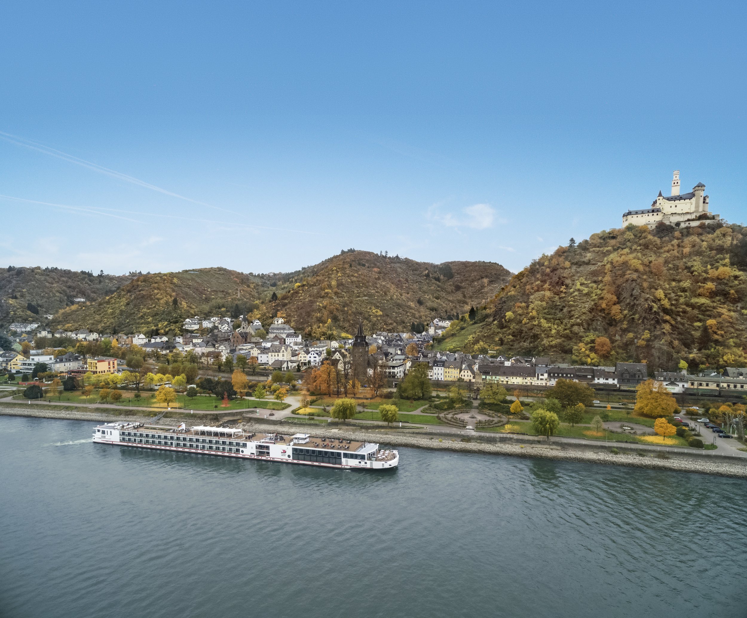 Viking River cruise ship sailing past Marksburg Castle on the Rhine River in Germany during autumn