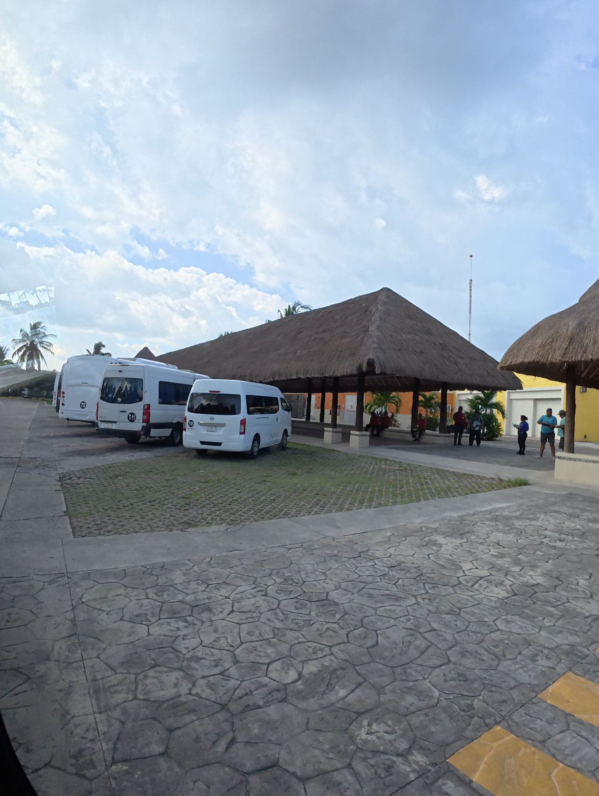 Vans used for cruise excursion transportation parked at the entrance of Islands Beach Club in Cozumel.