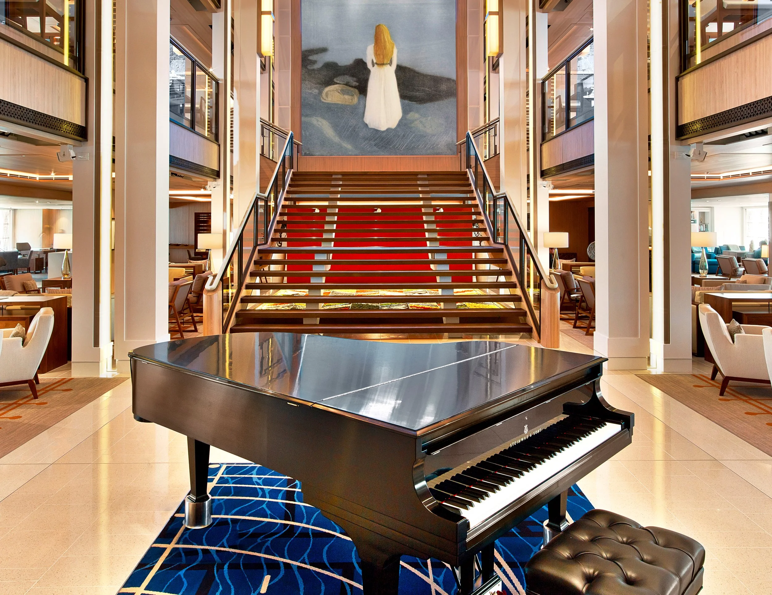 Grand staircase and piano in Viking Ocean ship atrium showcasing Scandinavian minimalist design