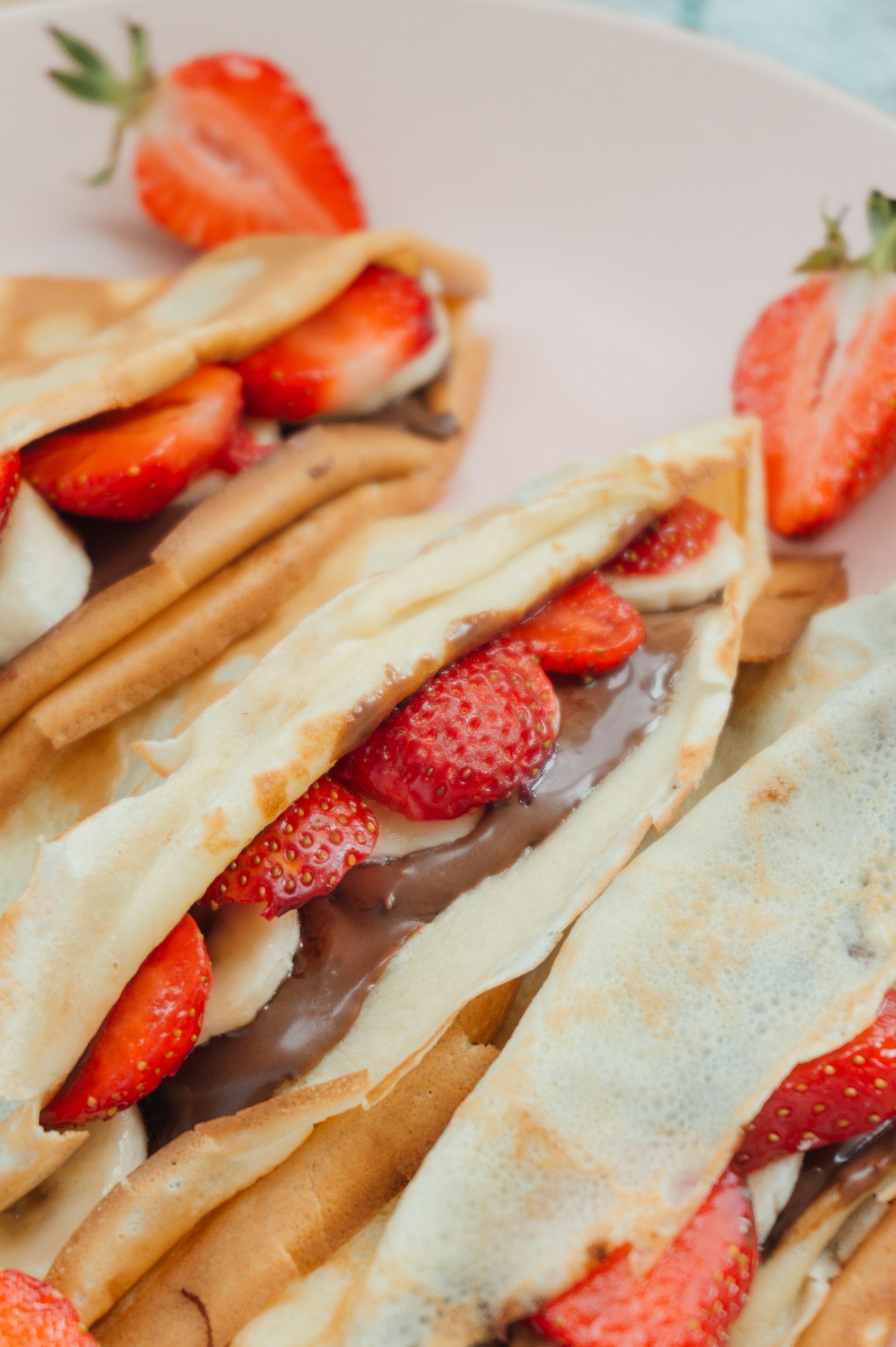 Close-up of a waffle filled with strawberries, chocolate, and cream.