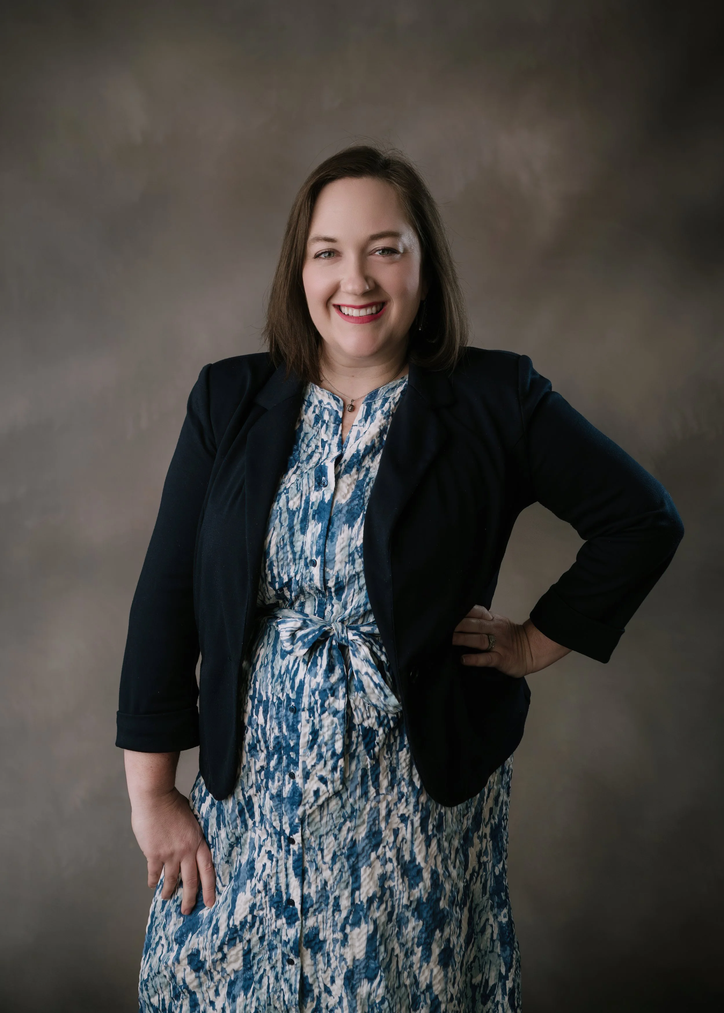 Rosamarie smiling and standing with hands on hips looking at camera.