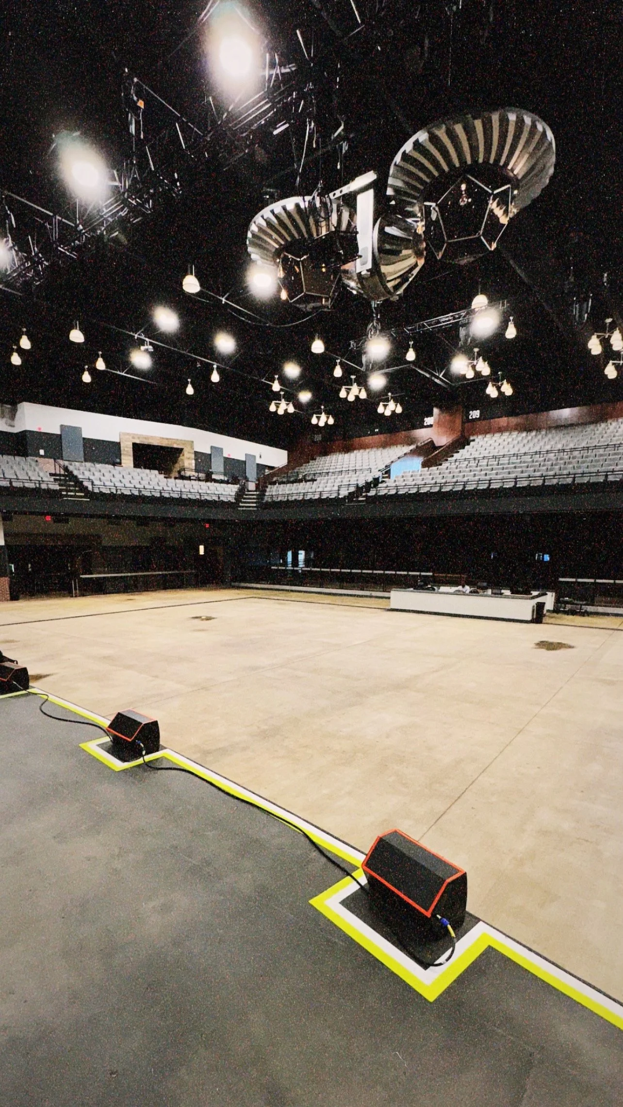 Empty concert hall with stage, seating, and overhead lighting.