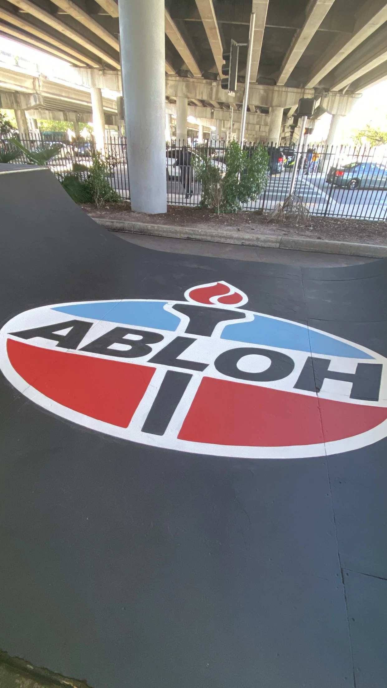 Skate ramp under bridge with 'ABLOH' logo.