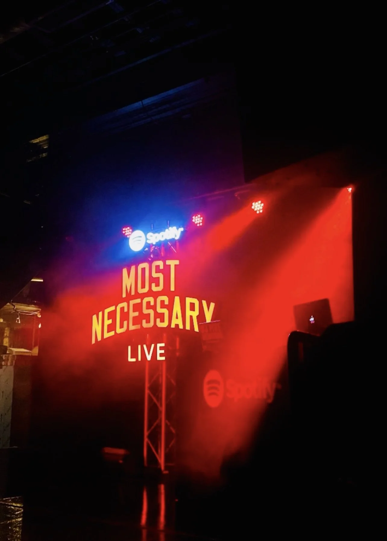 Stage with Spotify branding and 'Most Necessary Live' lighting.