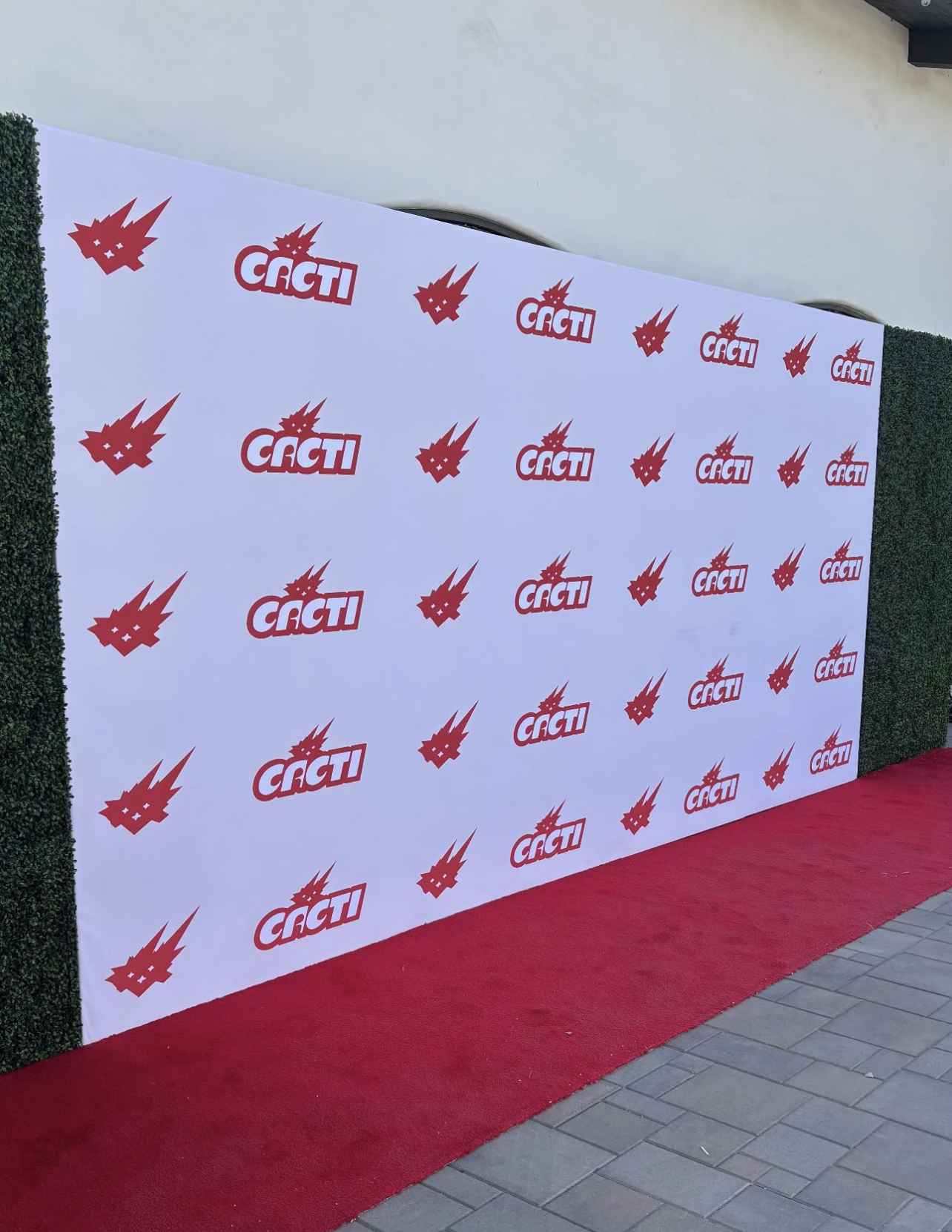 Red carpet event backdrop with Cacti logo and graphics.