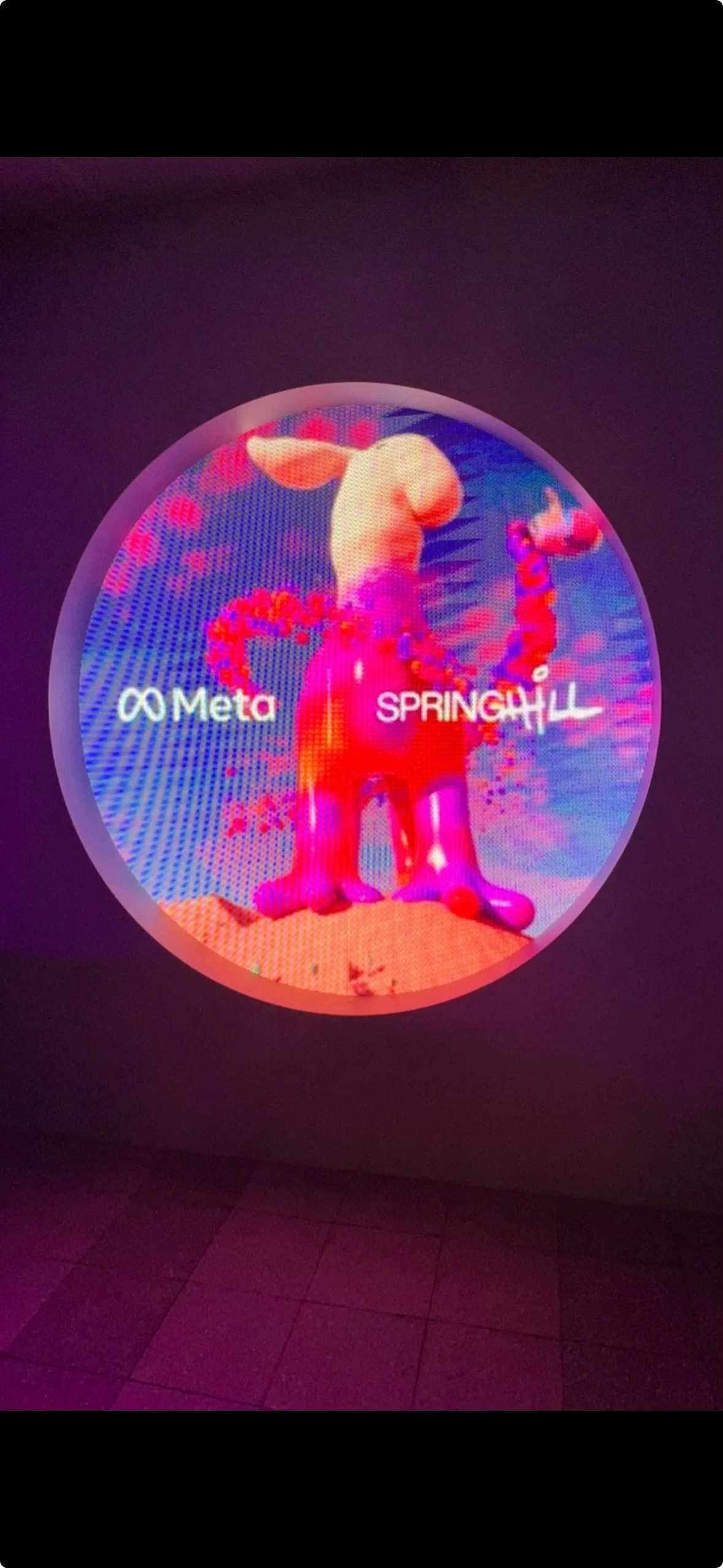 Circular digital display with abstract colorful shapes and text "Meta" and "SPRINGH\LL."