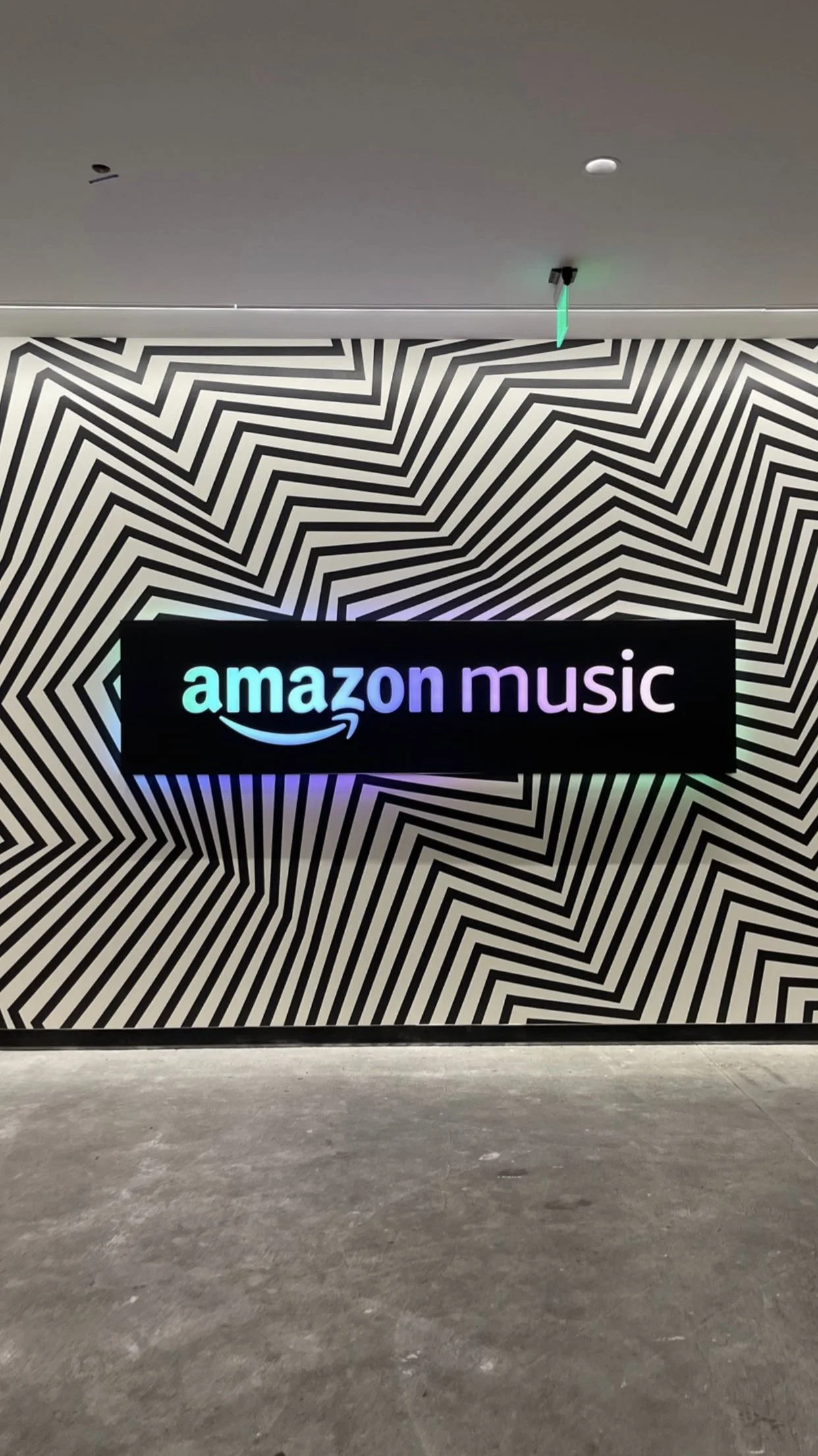 Amazon Music sign on a black and white geometric patterned wall.