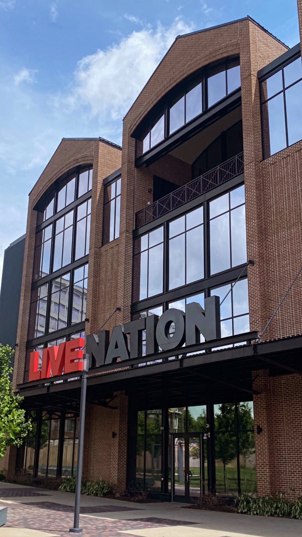 Building with "Live Nation" sign, large arched windows, and brick facade.