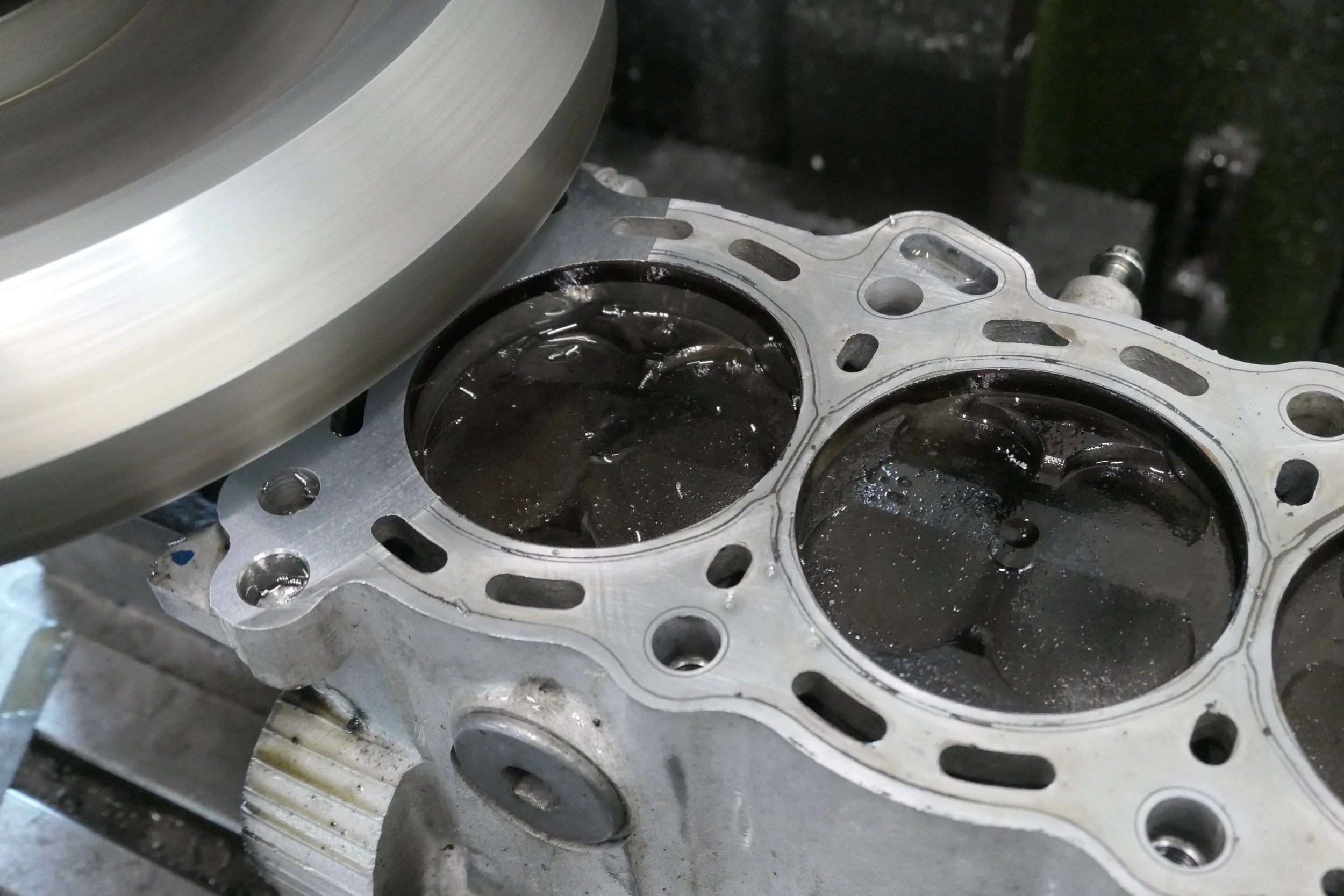 Blick auf einen Motorblock mit laufenden Kolben, die sich in den Zylindern bewegen, während der Motor läuft.