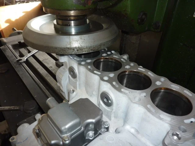 Ein Motorblock wird mit einem Schleifer bearbeitet.