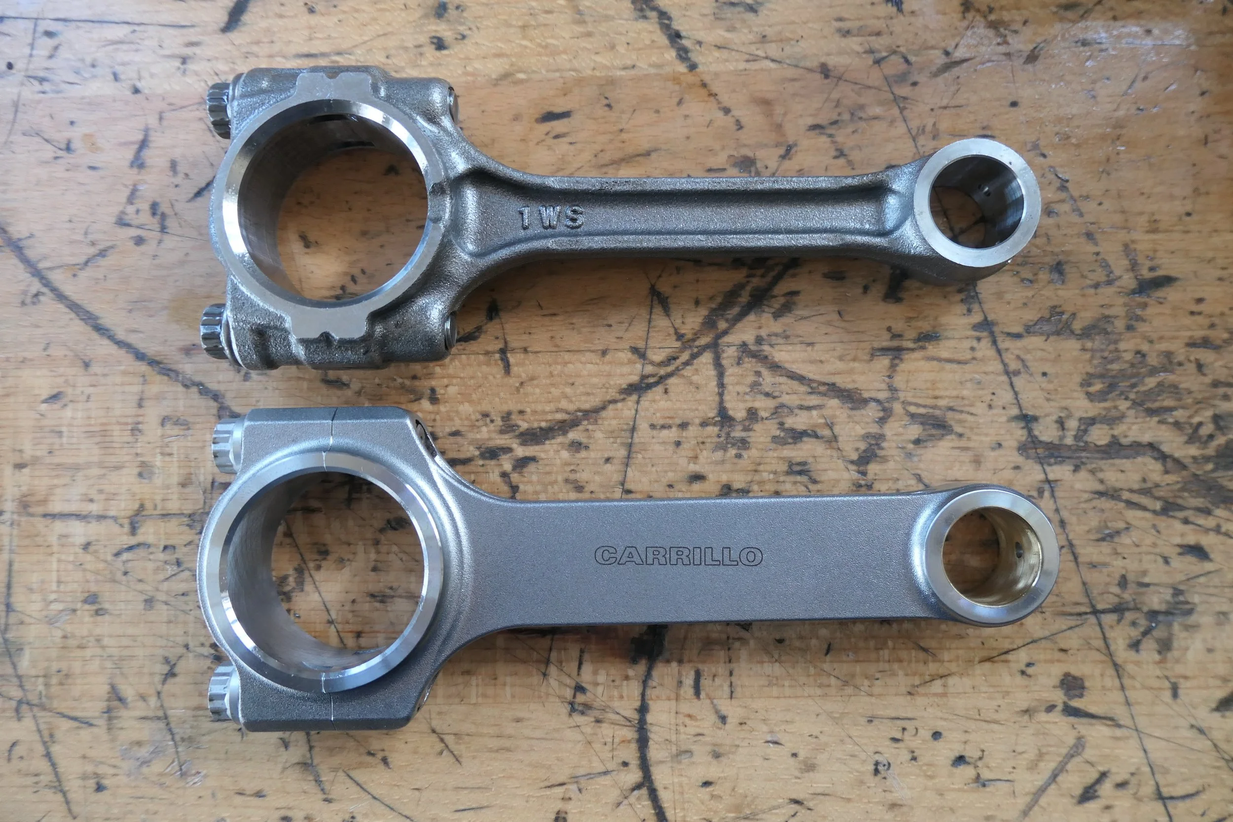 Zwei Fahrrad-Kurbeln, eine alte und eine neue, auf einem Holztisch.