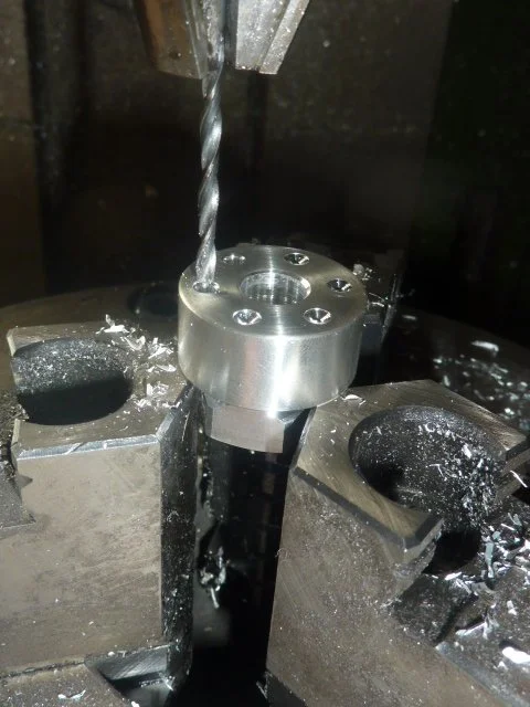 Fräser schneidet in einen metallischen Bauteil in einer Werkstatt.