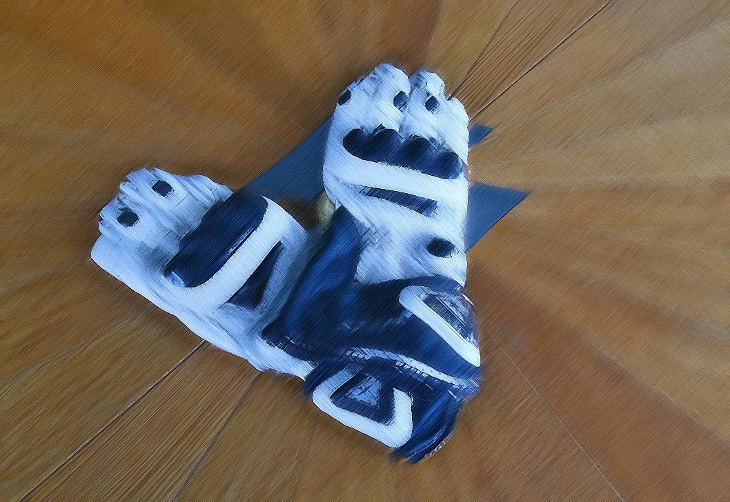 Ein Kunstwerk aus schwarzem und weißem Material, das auf einem Holztisch liegt, mit einer geschnitzten, abstrakten Gestaltung.