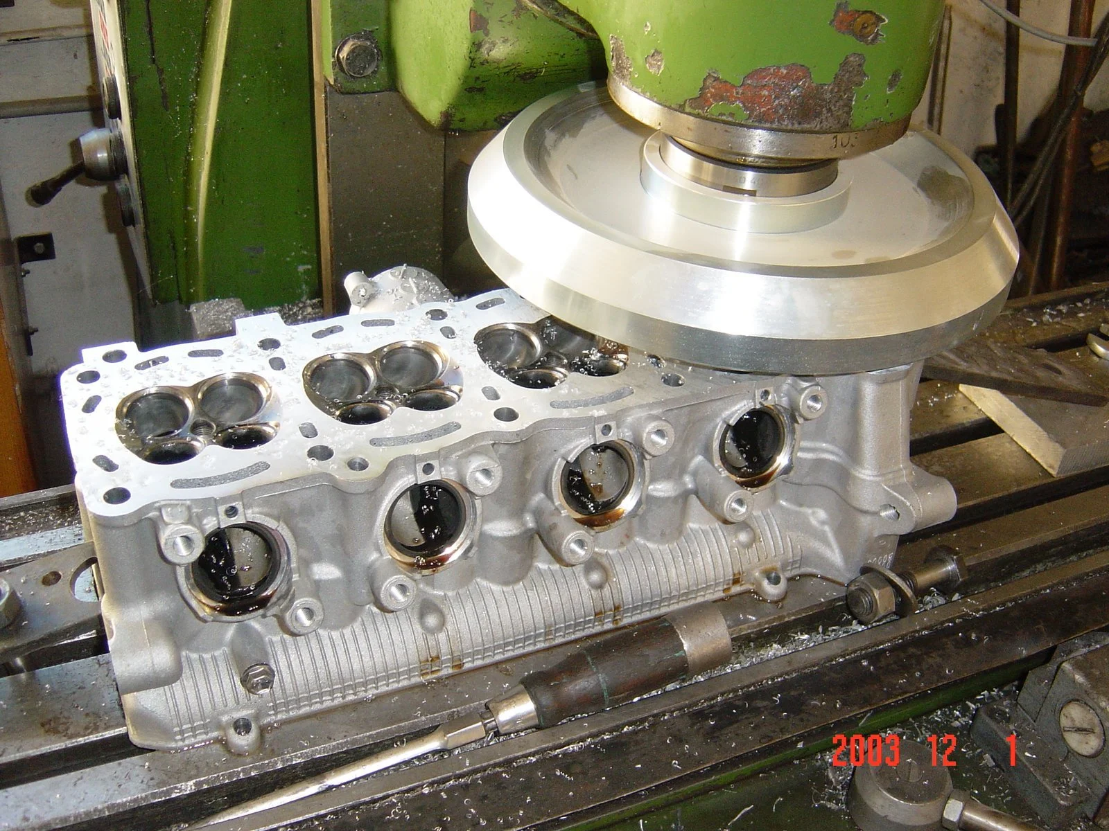 Ein Motorblock auf einer Werkbank, während eines Fräsprozesses, um die Oberflächen glatter zu machen, in einer Werkstatt.