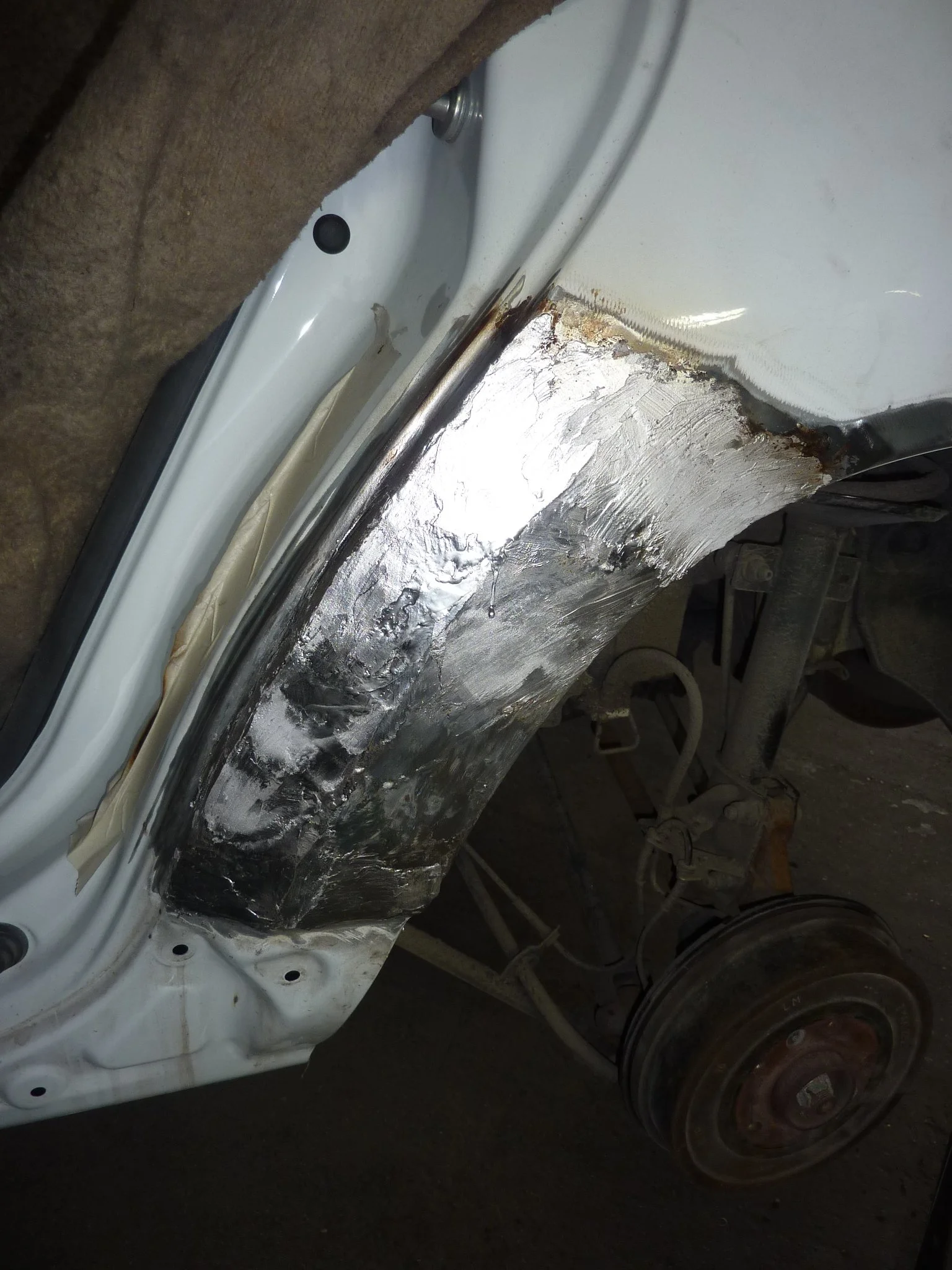 AutoKarosserie in Reparatur mit ungefährem Blechersatz und Schleifarbeiten an der Radhausschale