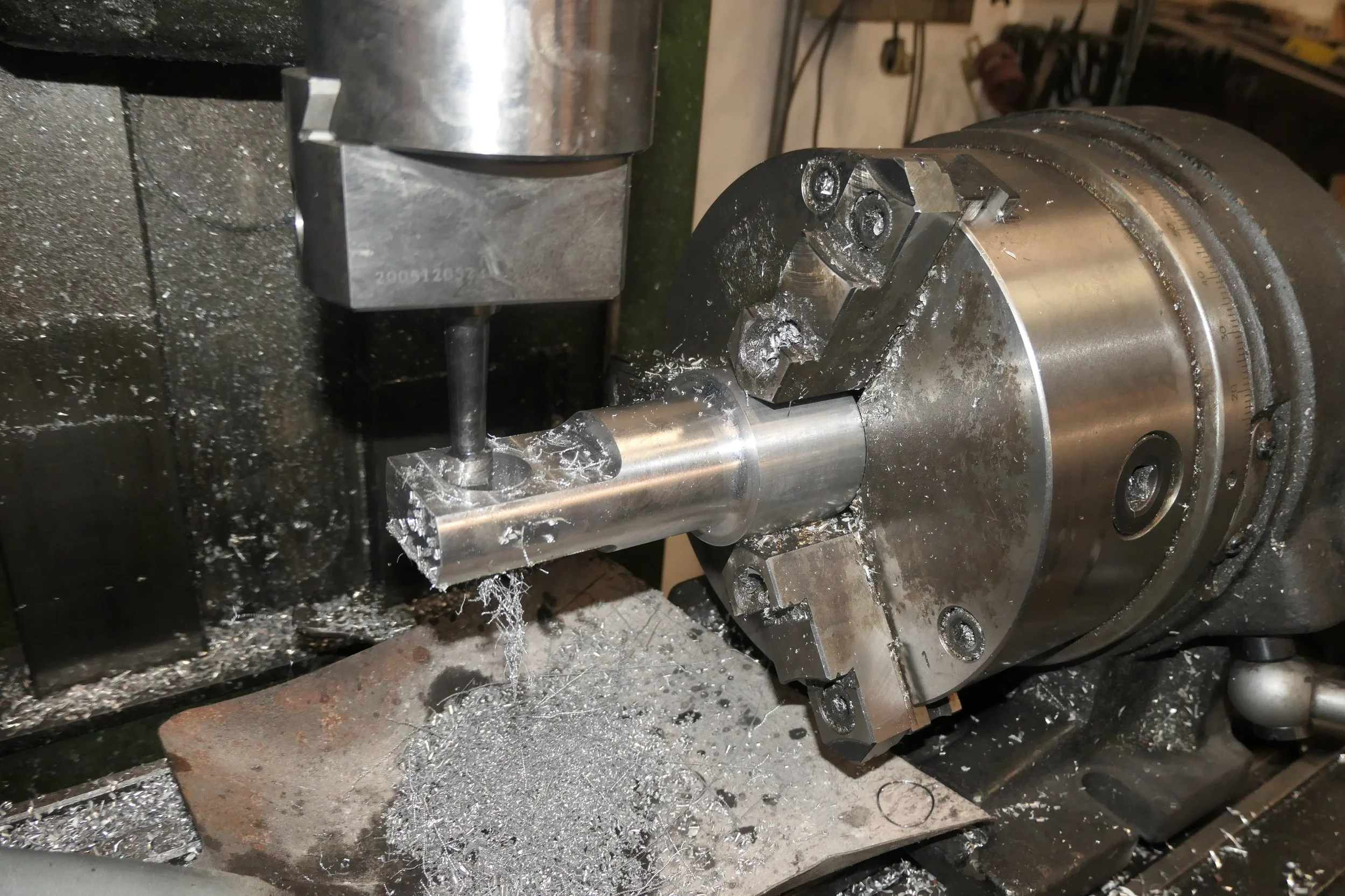 Metallbearbeitung an einer Maschine, die eine runde Metallstange in eine Maschine einspannt.