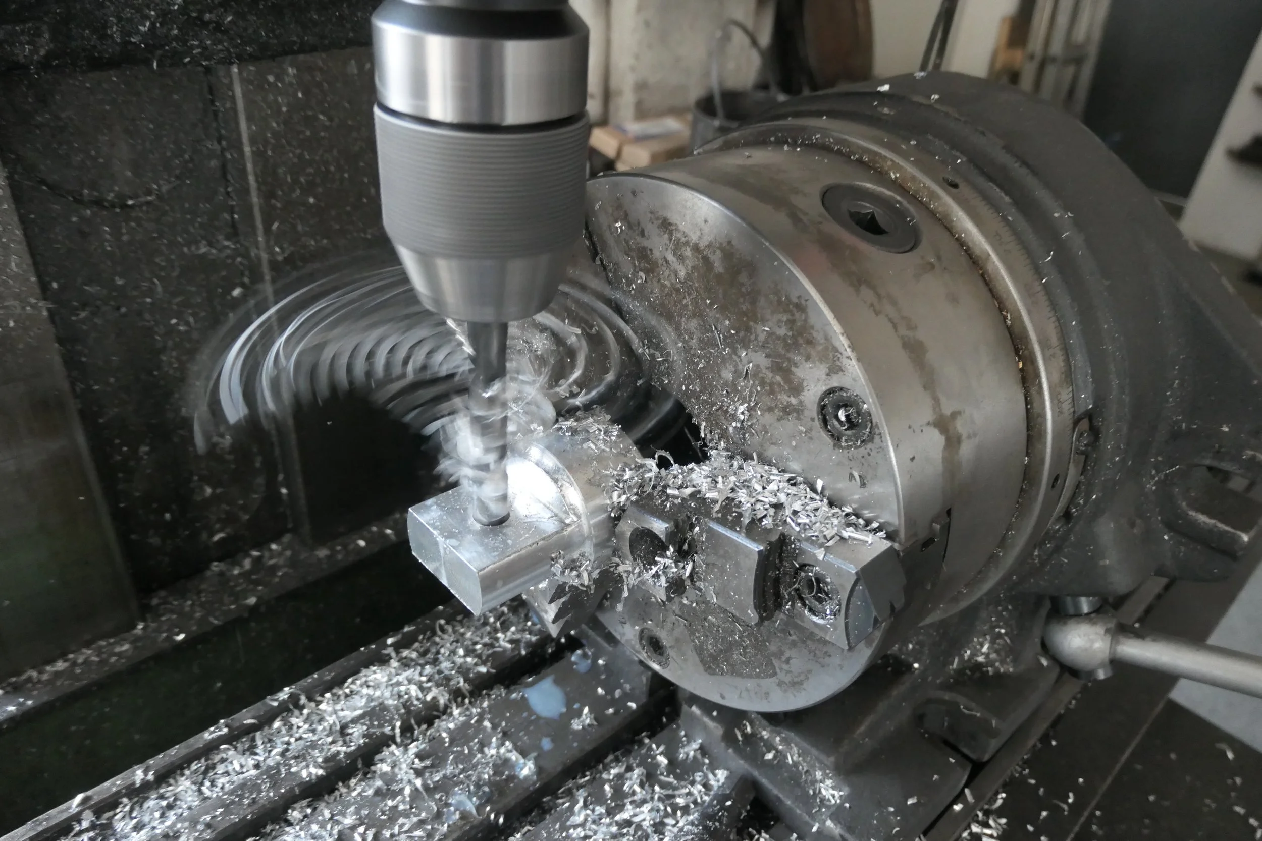 Fräsmaschine bei der Bearbeitung eines Metallstücks, Späne fliegen