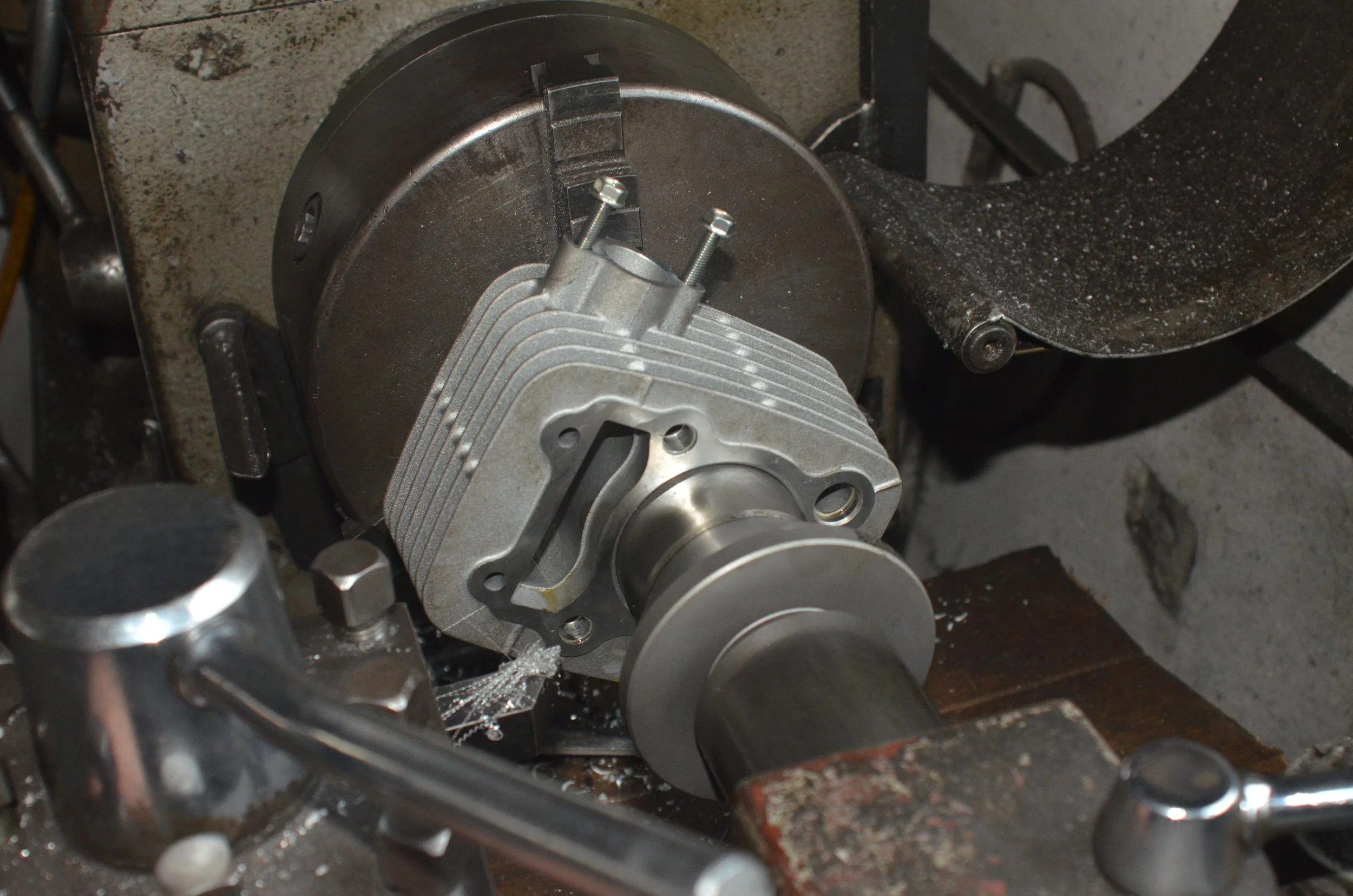 Fabrikation eines Motorradmotors auf einer Drehbank, mit Zylindermotorblock, Schrauben und Metallspänen.