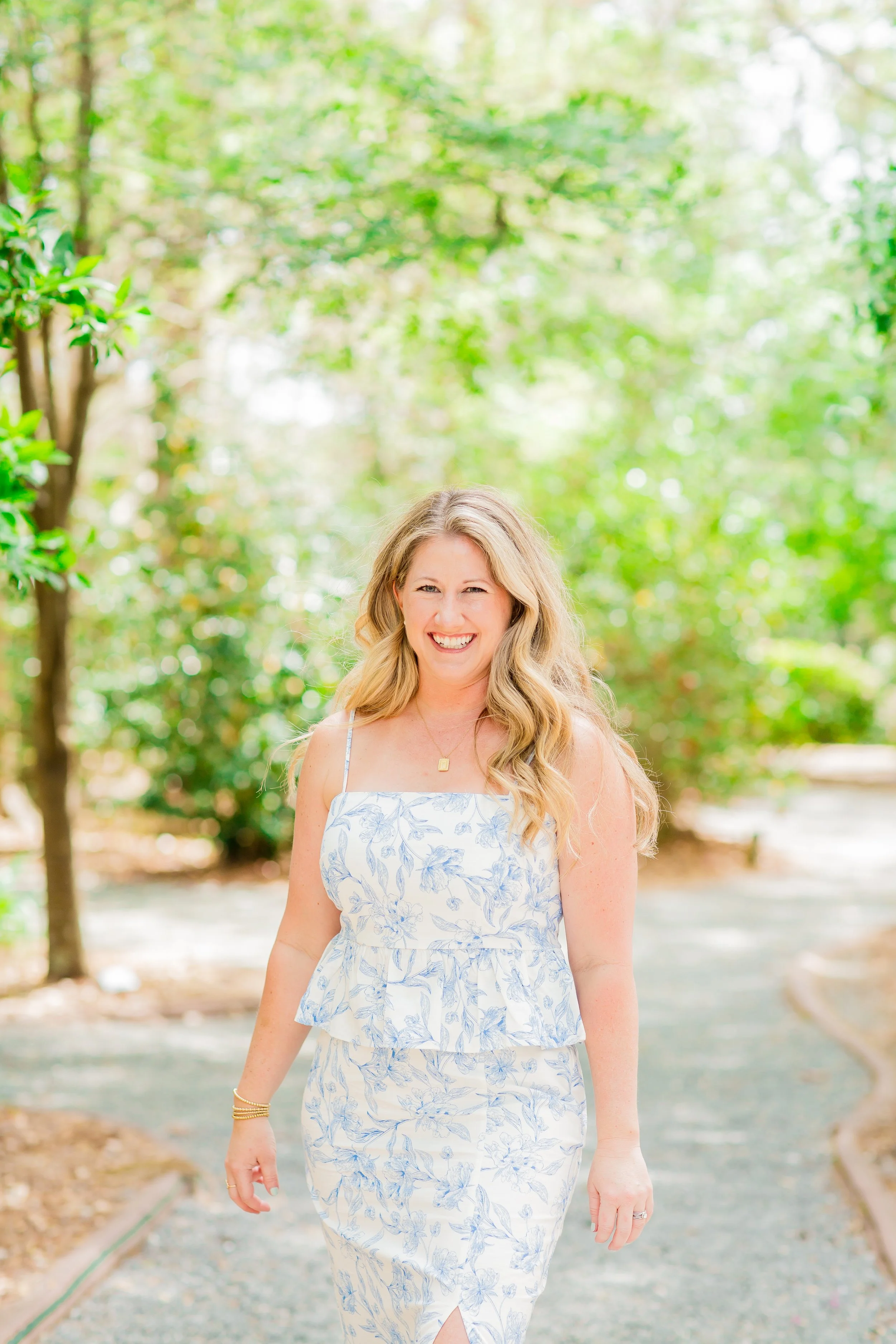 Woman in floral dress walking on a garden path