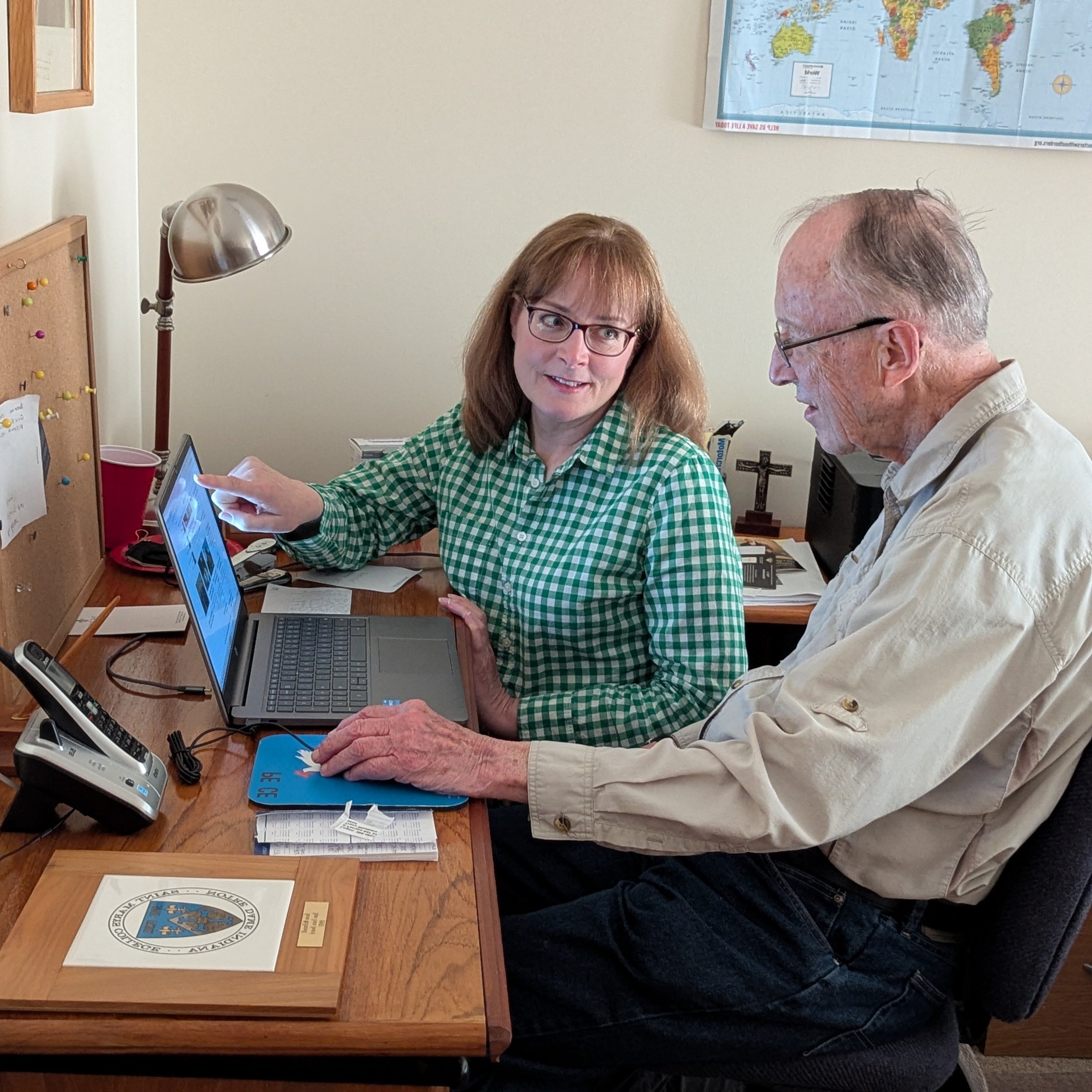 Woman and older man looking at laptop computer. Senior home care.