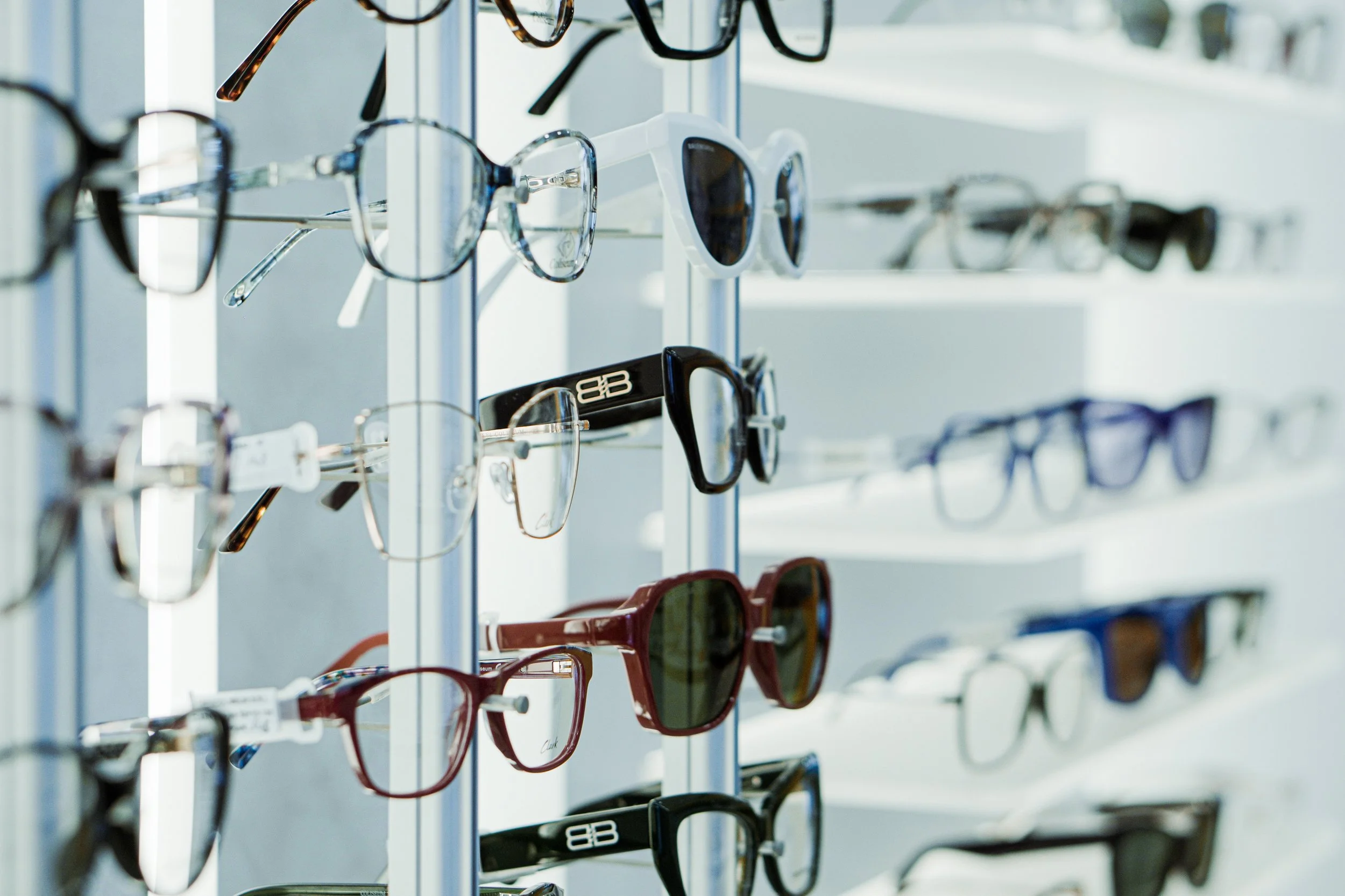 Lenti da sole e occhiali da vista esposti su scaffali metallici.