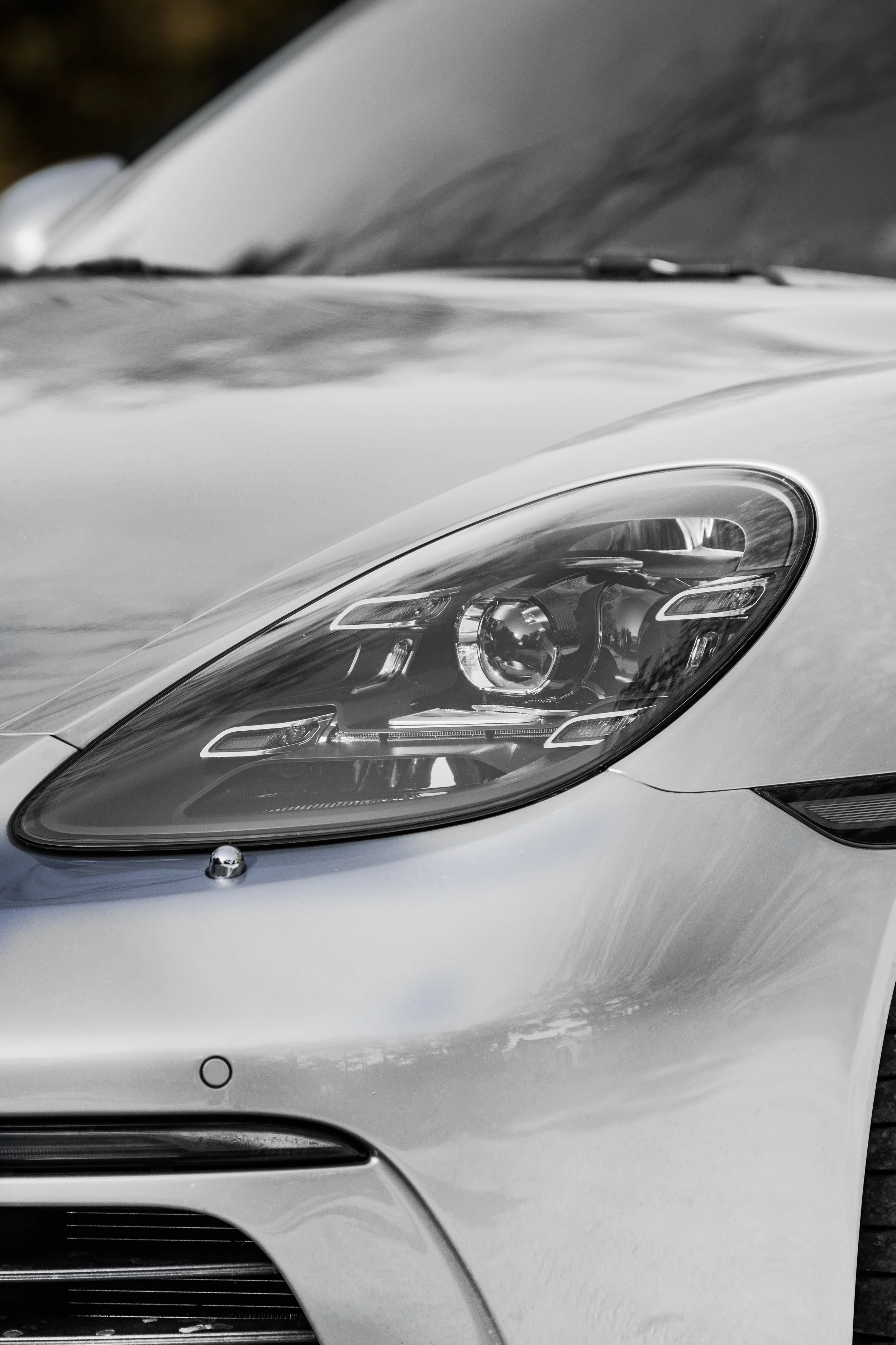 Primo piano di faro anteriore di un'auto di colore argento o grigio