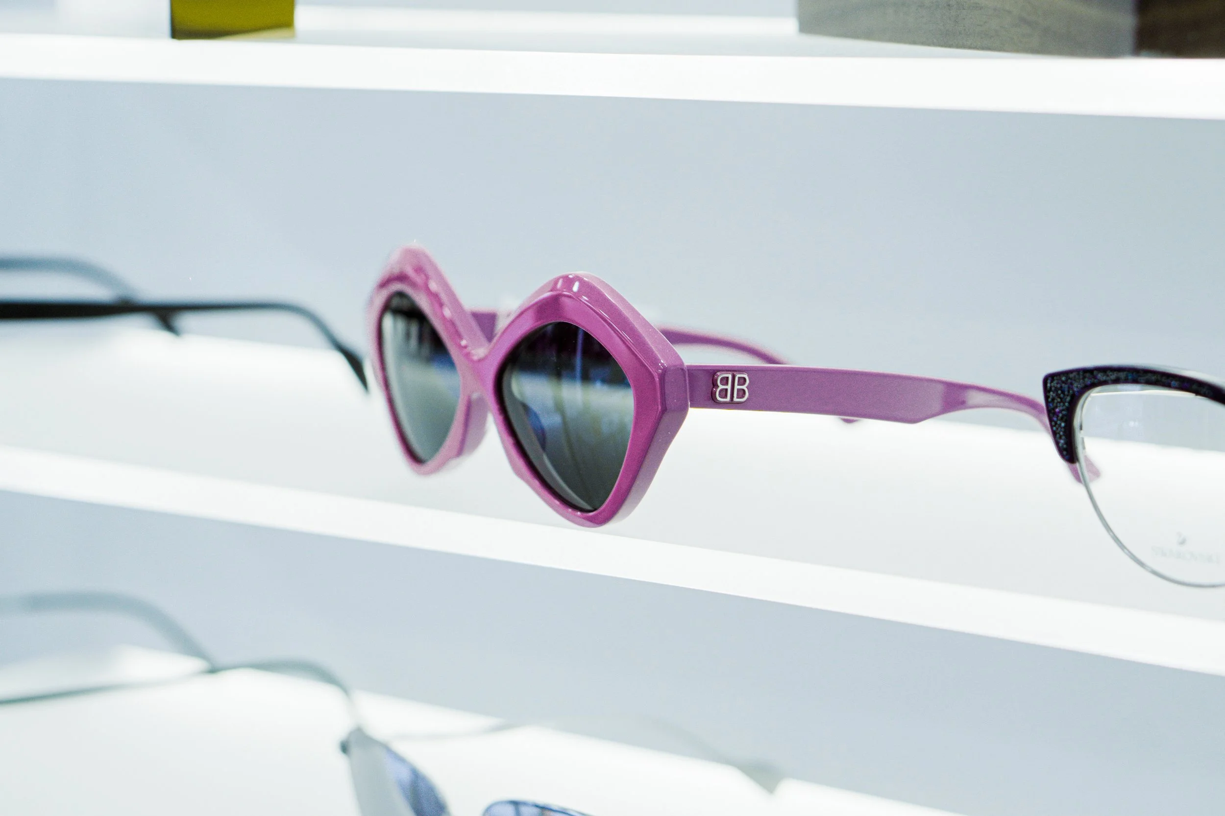 Occhiali da sole rosa con lenti scure su esposizione