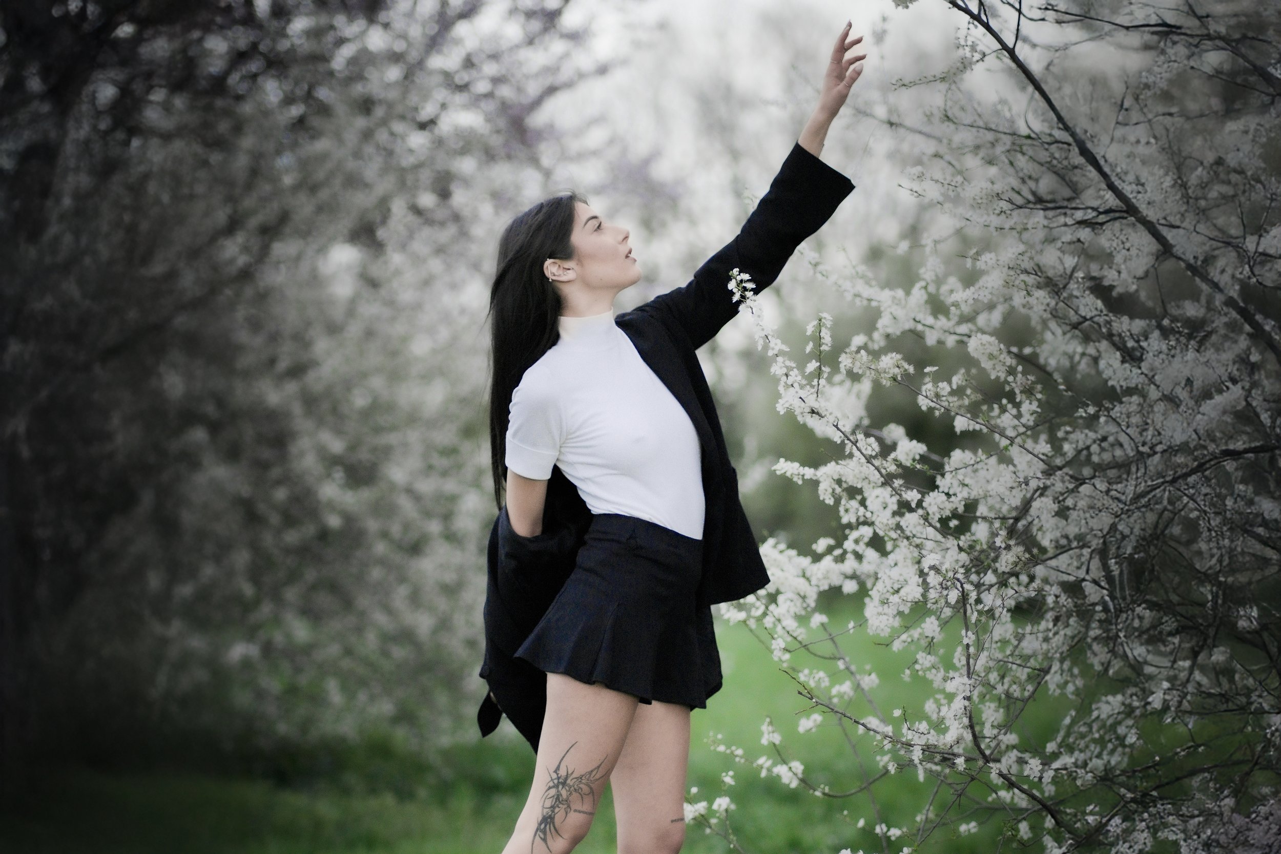 Una donna con abbigliamento scolastico che si trova in un boschetto di fiori bianchi