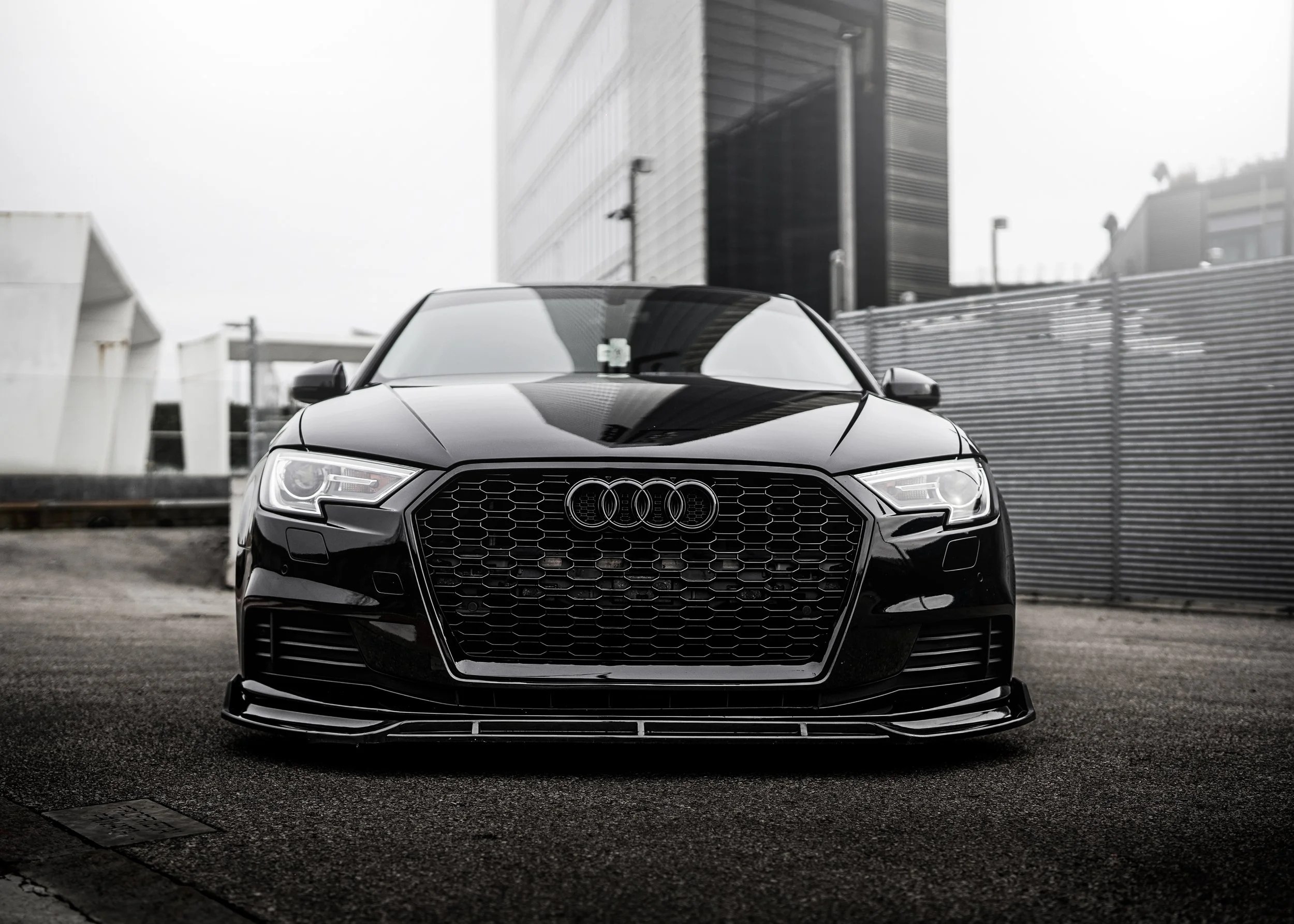 Auto sportiva nera parcheggiata in un'area urbana moderna