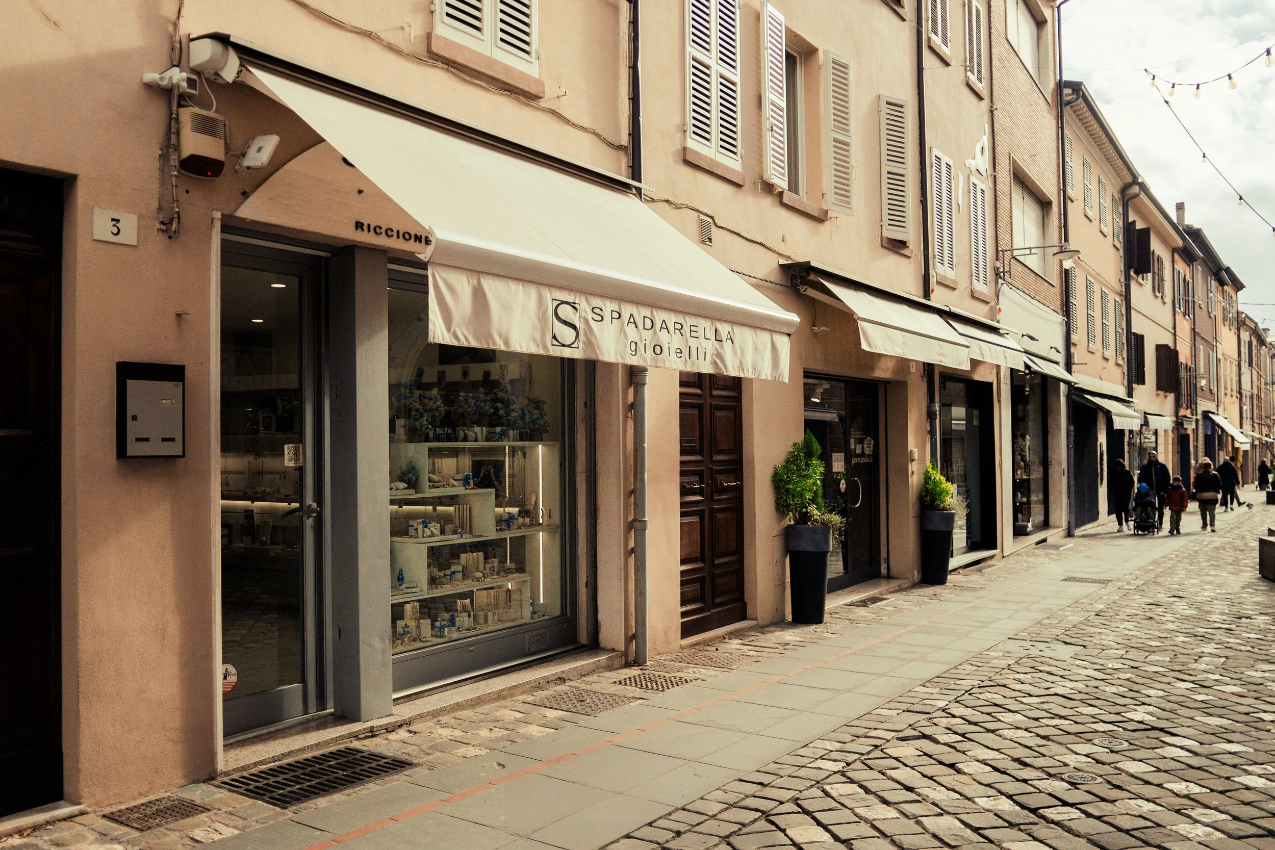 Vetrina di gioielli e negozio chiamato Spadarella Gioielli su una strada pietra