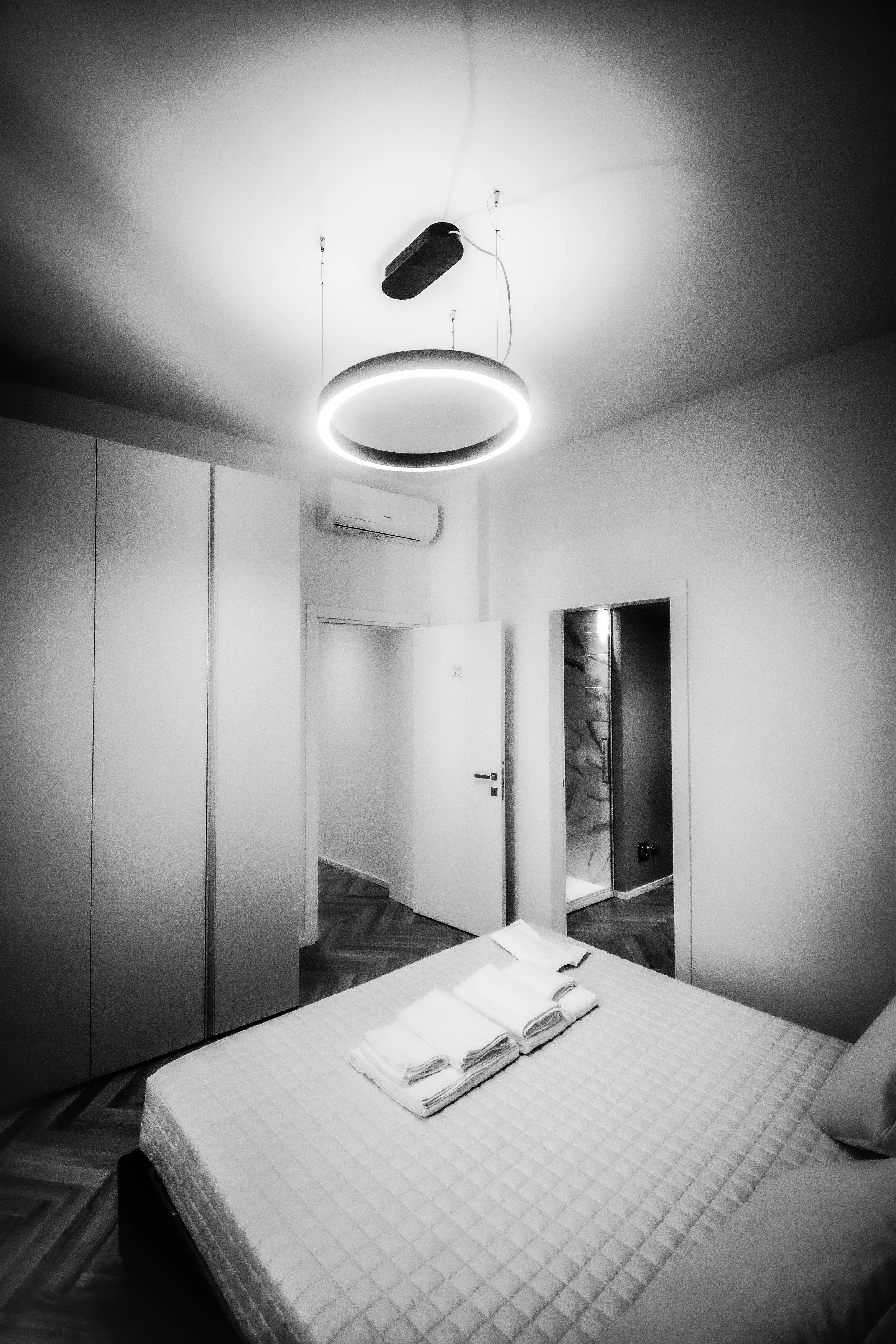 Camera da letto moderna con letto, armadio, aria condizionata e lampada a soffitto a LED.