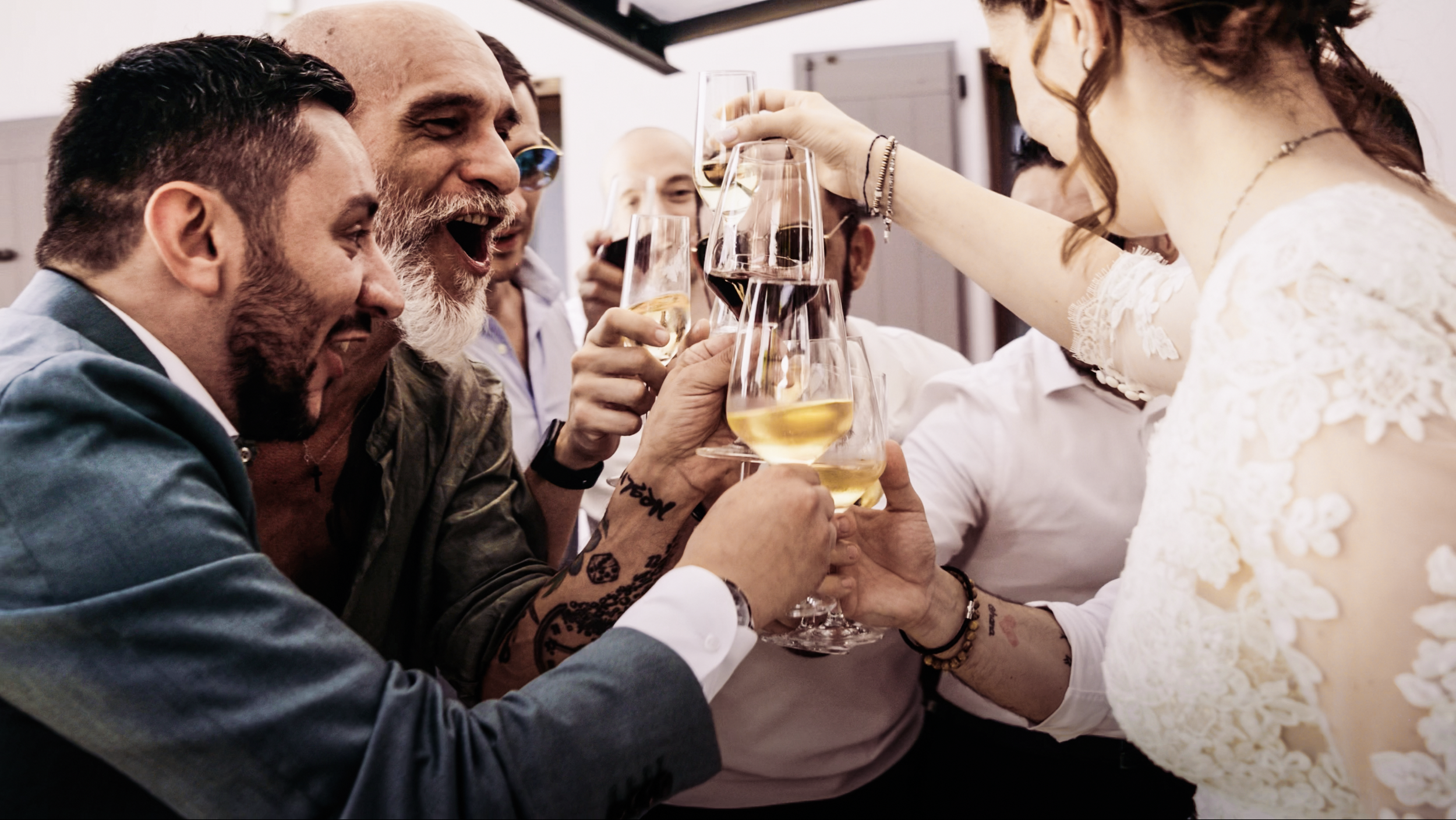 Gruppo di persone che brinda con bicchieri di vino in un'occasione festiva.