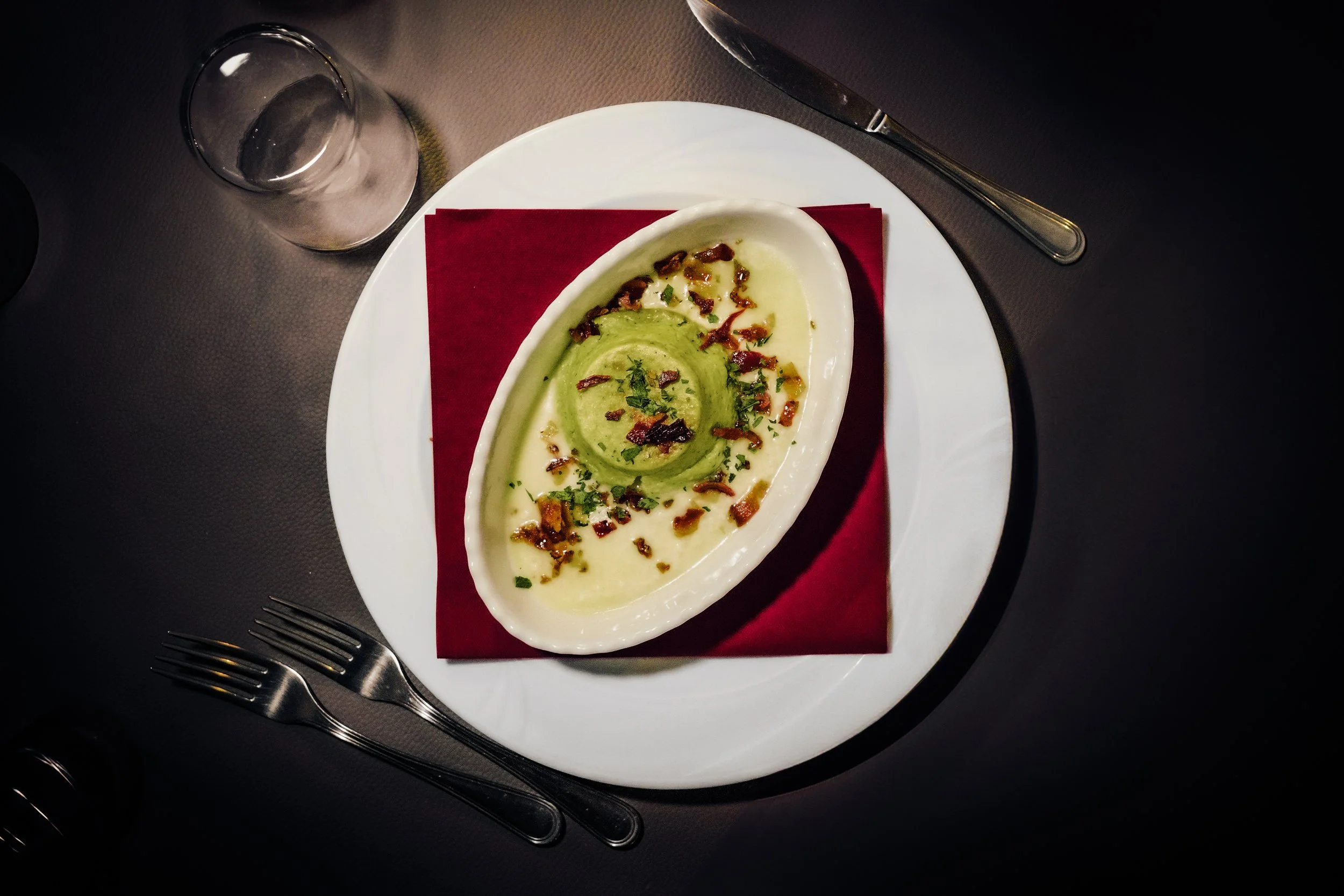 Zuppa di patate con guarniture di bacon croccante e cipolle.