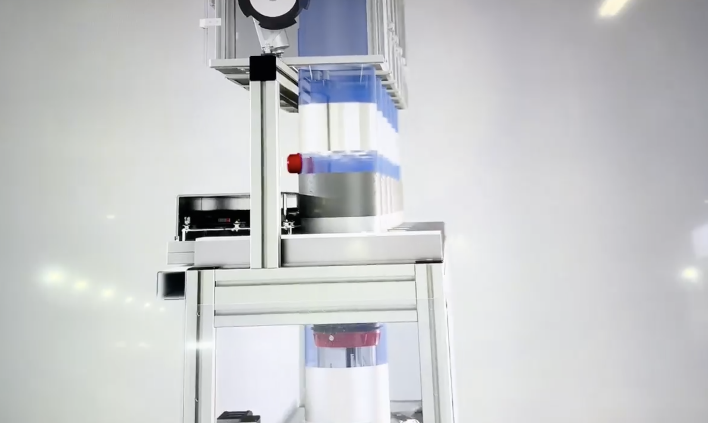 A machine with transparent containers and mechanical parts in a clean, white environment.