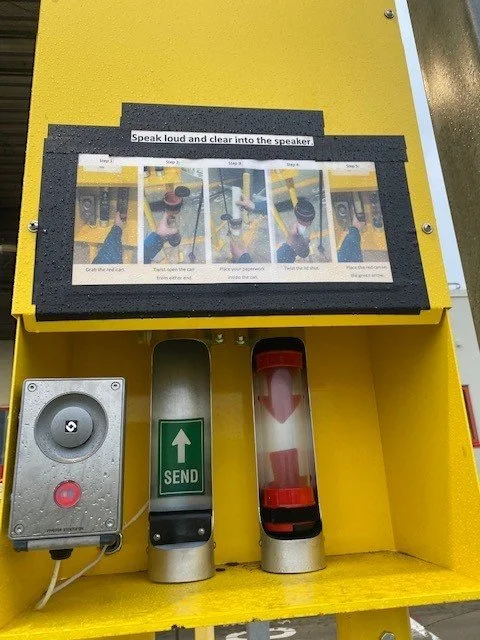 Instruction sign on a yellow public speaking practice device with a speaker, a green 'send' button, and a red timer.