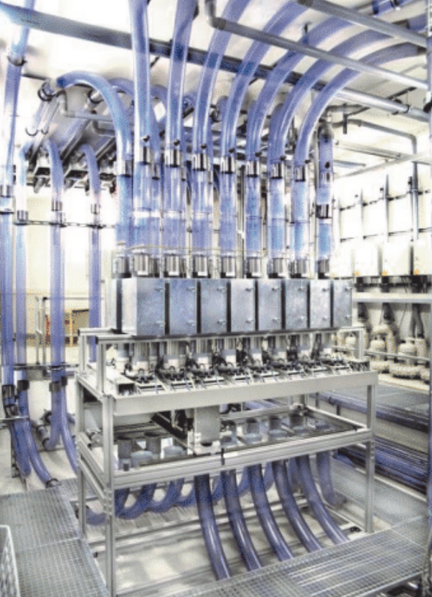 Industrial equipment with multiple blue tubes and metallic components in a manufacturing setting.