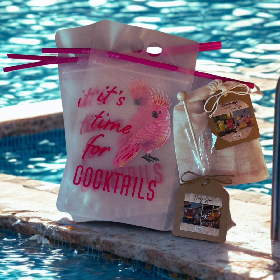 Poolside bag with pink straw, pink flamingo graphic, and the text 'it’s time for COCKTAILS' next to the swimming pool.