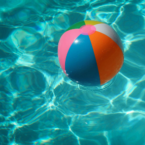 Colorful beach ball floating on swimming pool water.
