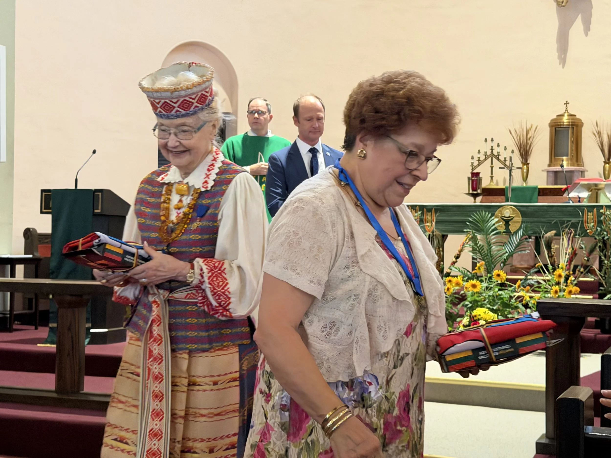 Barbara Schmidt, president of Council 141, and Marlene Warren, Council 7, accepting flags from the consul general