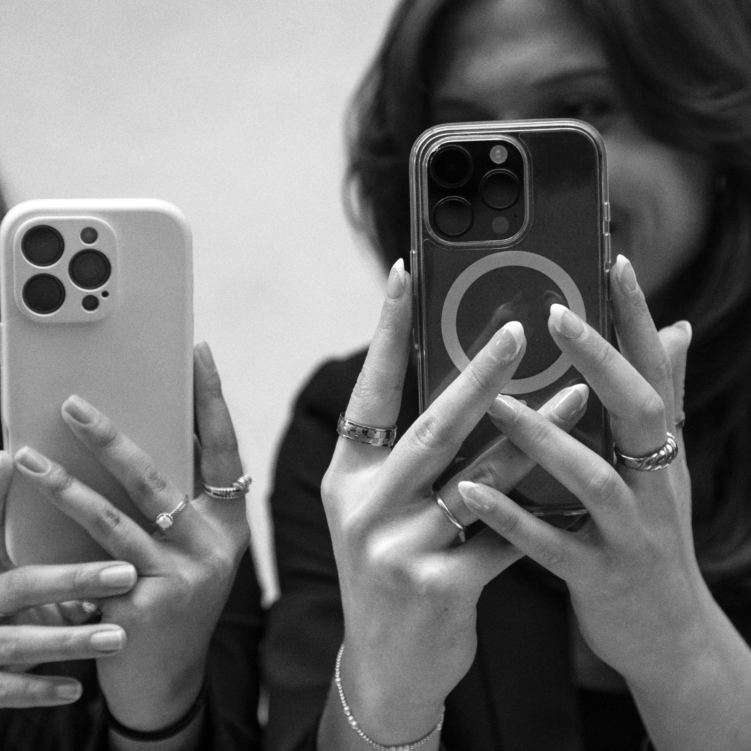Two Marker Digital team members creating social media content on their phones.