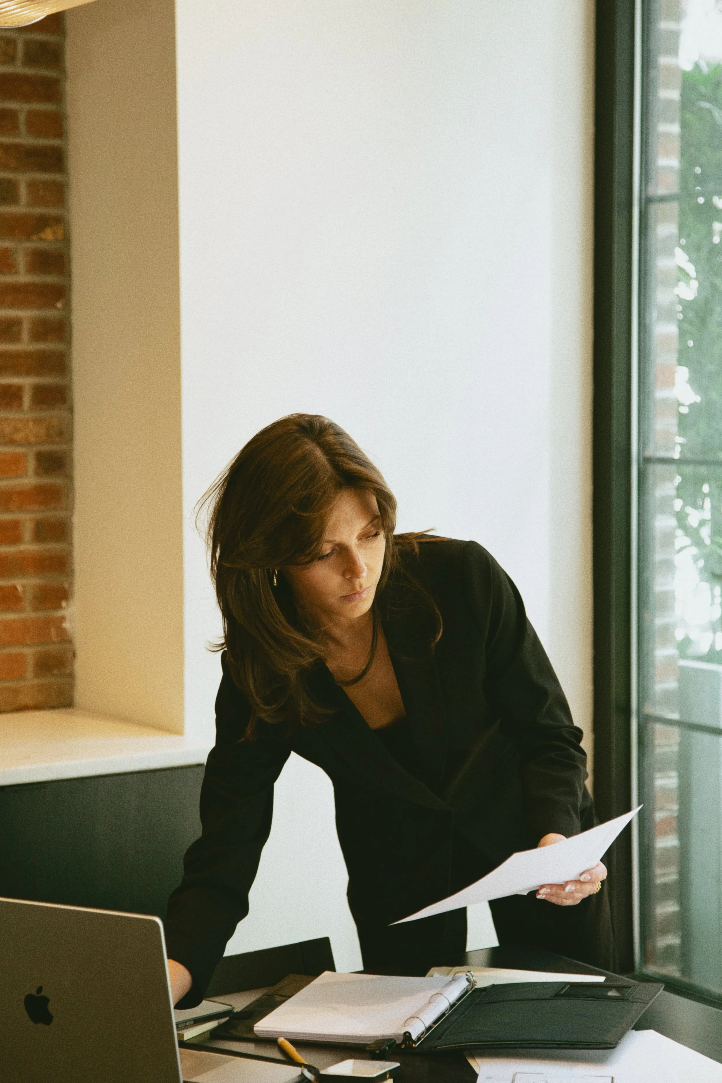 Kay Walker reviewing a digital marketing plan beside her laptop.