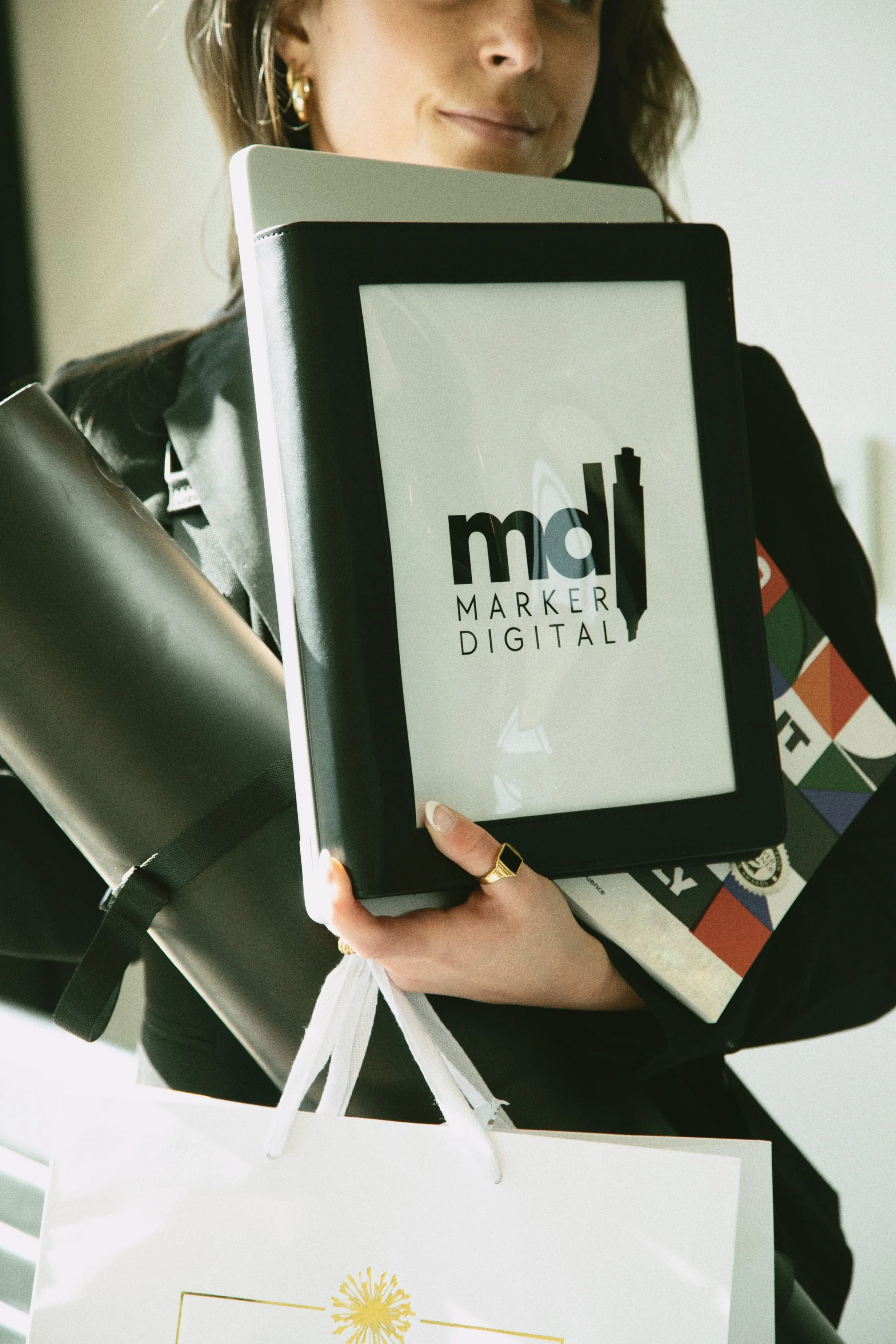 Kay Walker holding Marker Digital project materials and a branded tablet.