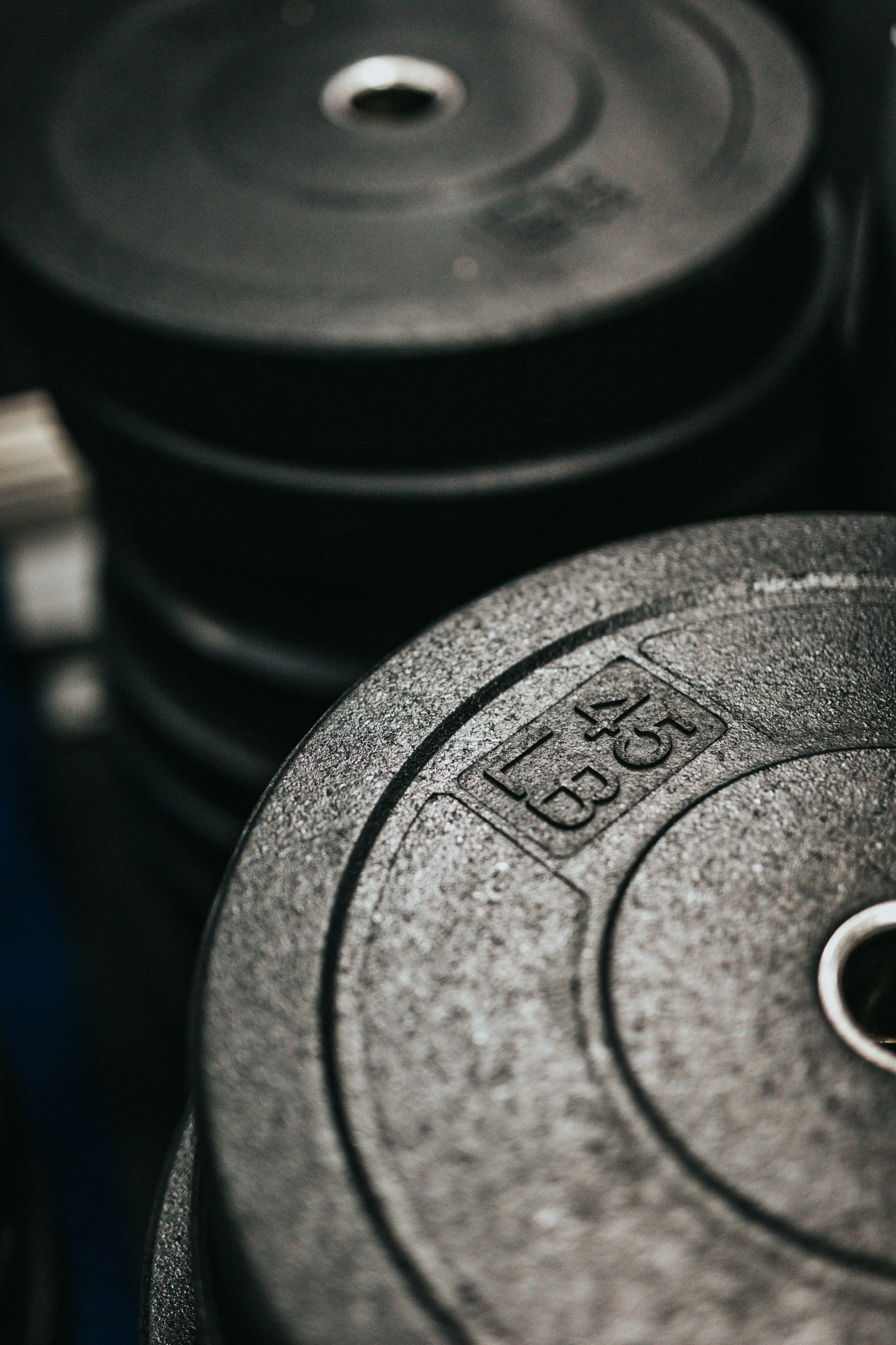 Photo en gros plan de disques de poids en métal utilisés pour l'exercice physique, avec inscription "10 KG" sur le disque en premier plan.