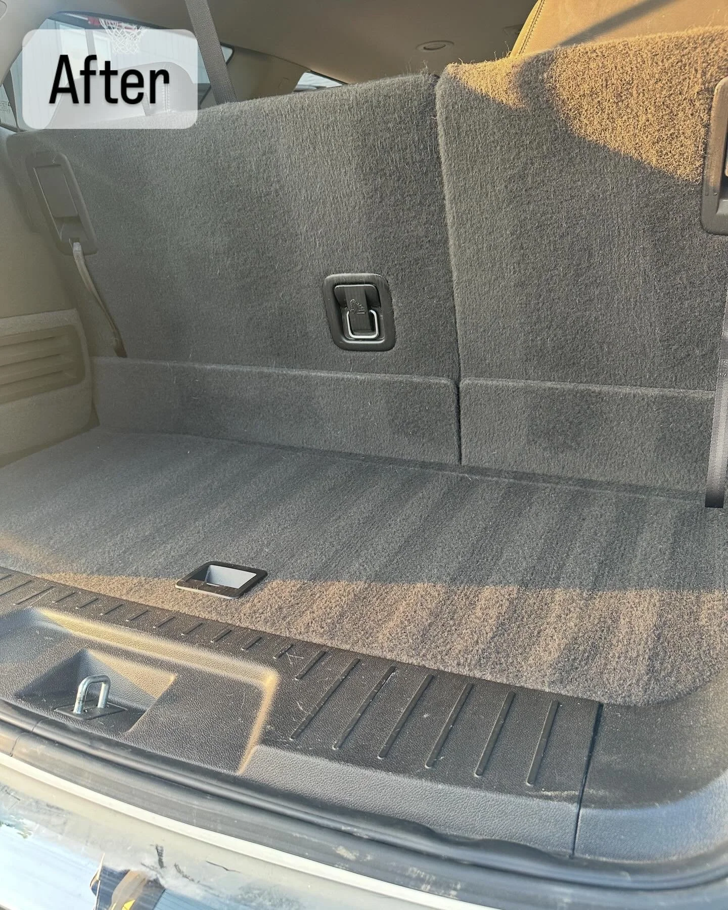 The back of a vehicle's cargo area with a flat, carpeted surface, a fold-down seat covered in fabric, and a latch handle on the seat's backrest. The word 'After' is overlaid in the upper left corner.