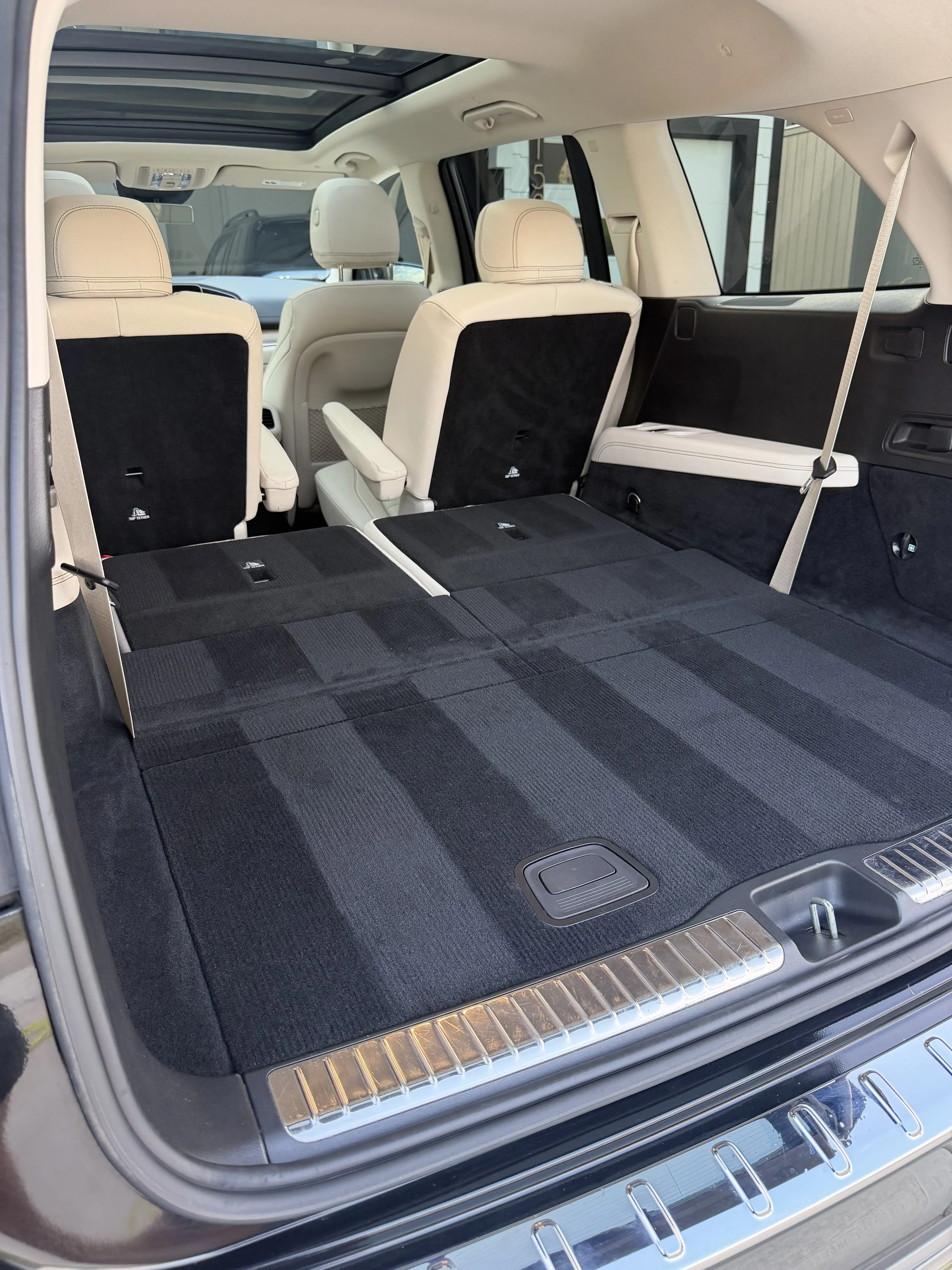 Interior of an SUV with the third-row seats folded down and a panoramic sunroof.